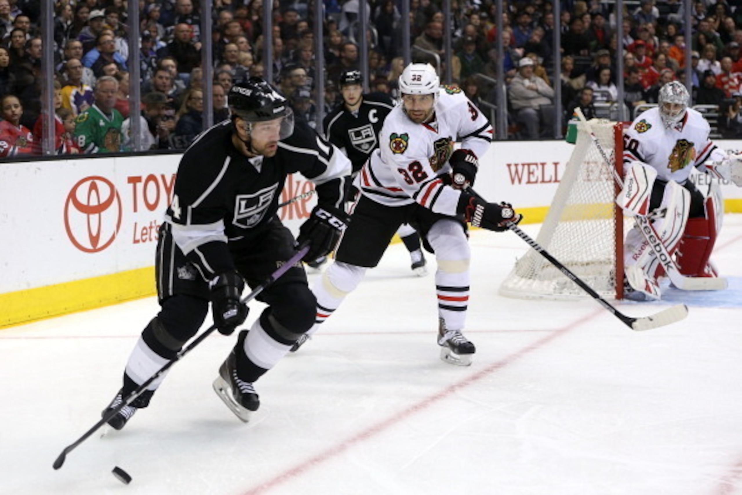 LOS ANGELES, CA - FEBRUARY 03:  Justin Williams #14 of the Los Angeles Kings plays the puck around the net as Michal Rozsival #32 of the Chicago Blackhawks tries to defend the play in the second period during the NHL game at Staples Center on February 3,