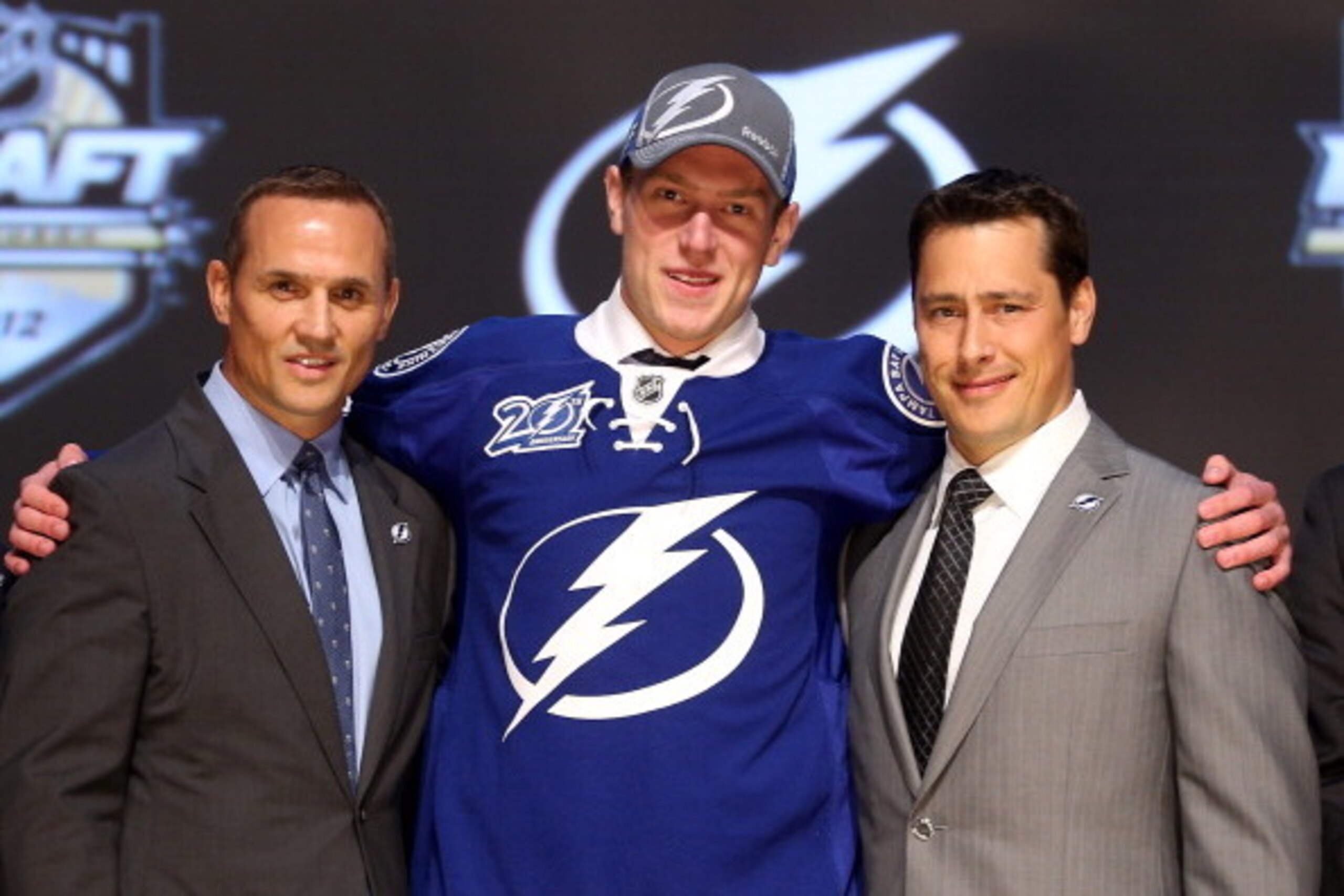 PITTSBURGH, PA - JUNE 22:  Slater Koekkoek (C), tenth overall pick by the Tampa Bay Lightning, poses on stage with general manager Steve Yzerman (L) and team representatives during Round One of the 2012 NHL Entry Draft at Consol Energy Center on June 22,