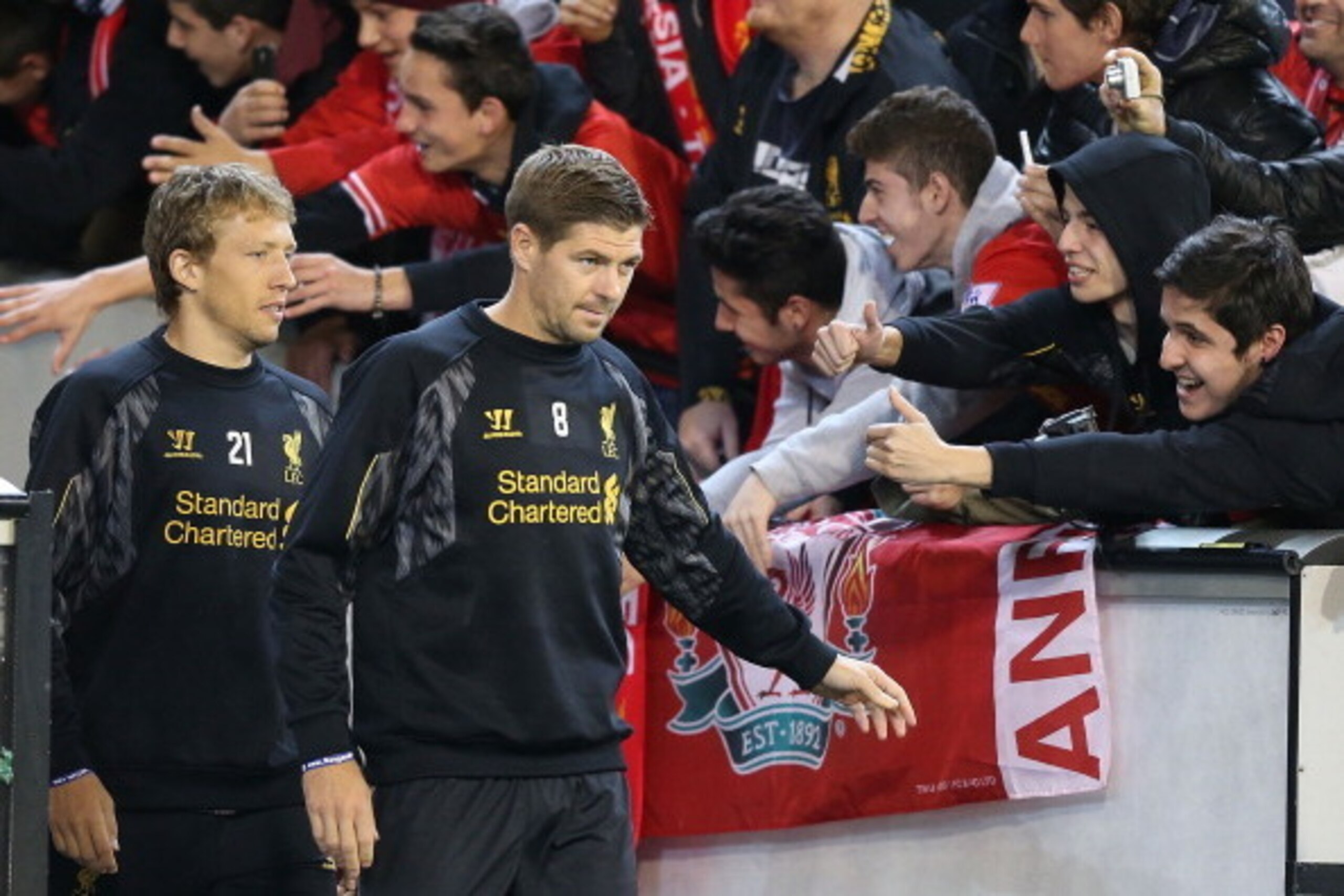 MELBOURNE, AUSTRALIA - JULY 23:  Liverpool fans reach out to Lucas Leiva (L) and Steven Gerrard who enter the field during a Liverpool FC training session at Melbourne Cricket Ground on July 23, 2013 in Melbourne, Australia.  (Photo by Michael Dodge/Getty
