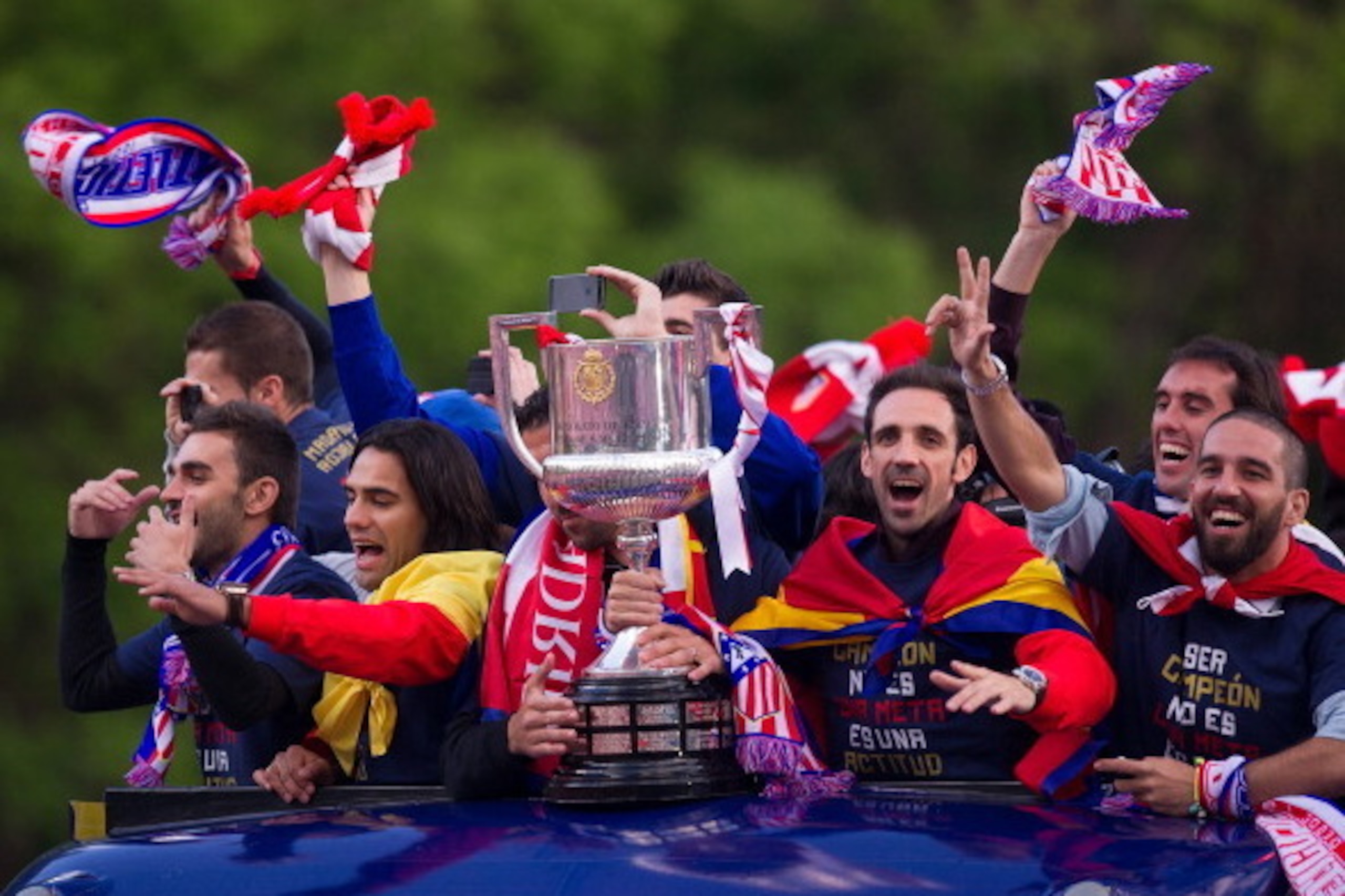 MADRID, SPAIN - MAY 18:  Juan Francisco 'Juanfran' (2. R) Adra Turan (R) and Radamel Falcao (L) of Atletico de Madrid celebrate from an open-top bus a day after winning the Copa del Rey Final against Real Madrid on May 18, 2013 in Madrid, Spain.  (Photo b