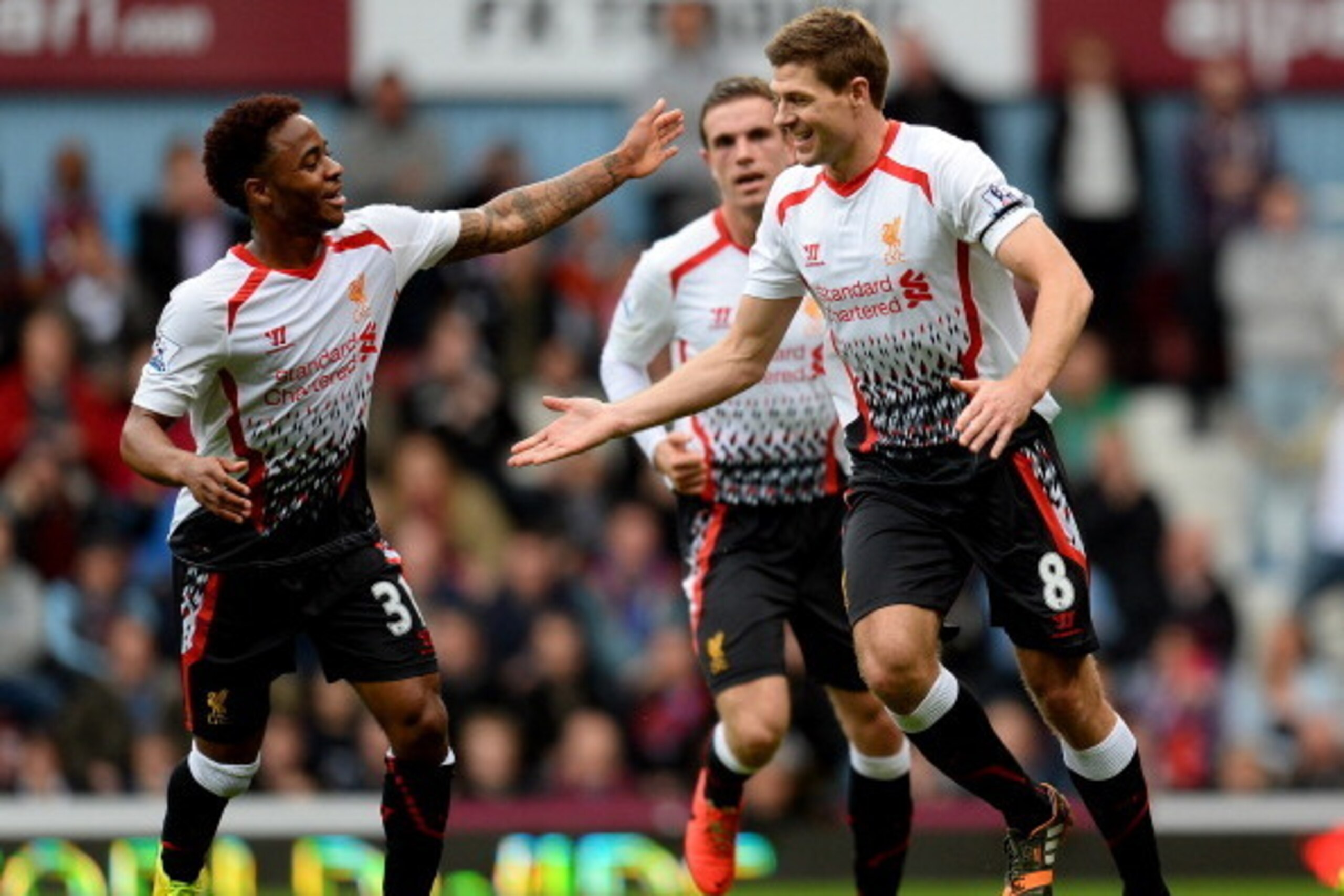 LONDON, ENGLAND - APRIL 06:  Steven Gerrard (C)of Liverpool celebrates with teammate Raheem Sterling (L) after scoring the opening goal from the penalty spot during the Barclays Premier League match between West Ham United and Liverpool at Boleyn Ground o