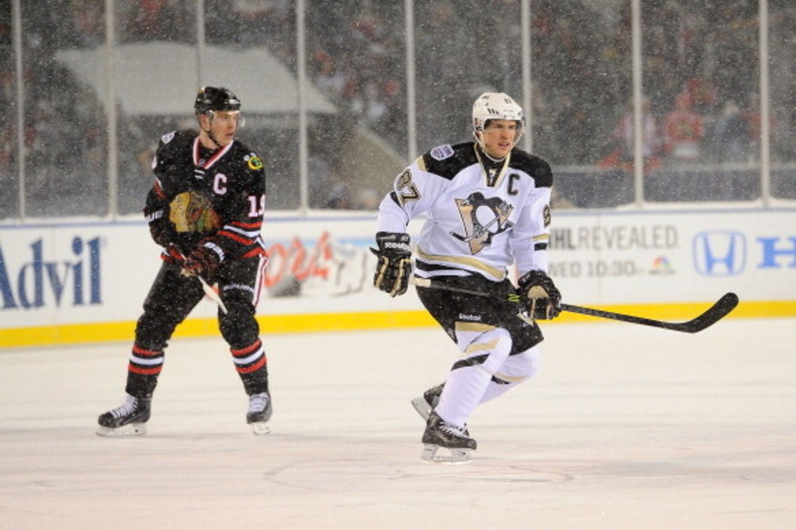 CHICAGO, IL - MARCH 01:  (EDITORIAL USE ONLY) Jonathan Toews #19 of the Chicago Blackhawks and Sidney Crosby #87 of the Pittsburgh Penguins skate through the neutral zone during the 2014 NHL Stadium Series game at Soldier Field on March 1, 2014 in Chicago