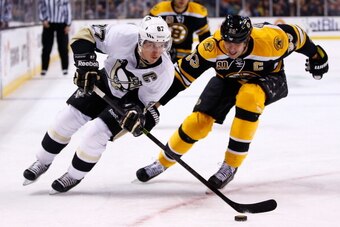 BOSTON, MA - DECEMBER 07:  Sidney Crosby #87 of the Pittsburgh Penguins carries the puck in front of a stickless Zdeno Chara #33 of the Boston Bruins in the second period during the game at TD Garden on December 7, 2013 in Boston, Massachusetts.  (Photo b