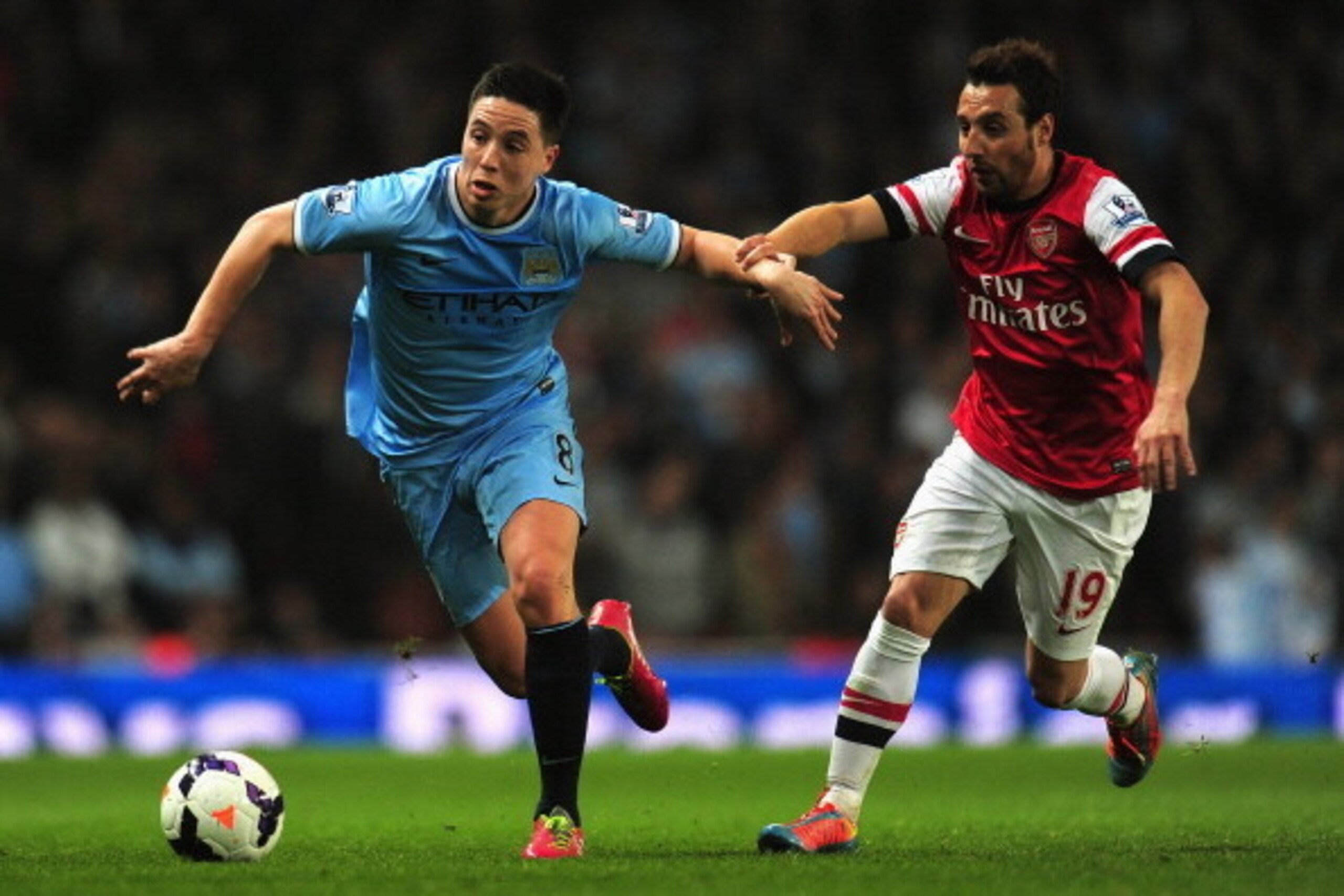 LONDON, ENGLAND - MARCH 29:  Samir Nasri of Manchester City and Santi Cazorla of Arsenal battle for the ball during the Barclays Premier League match between Arsenal and Manchester City at Emirates Stadium on March 29, 2014 in London, England.  (Photo by 
