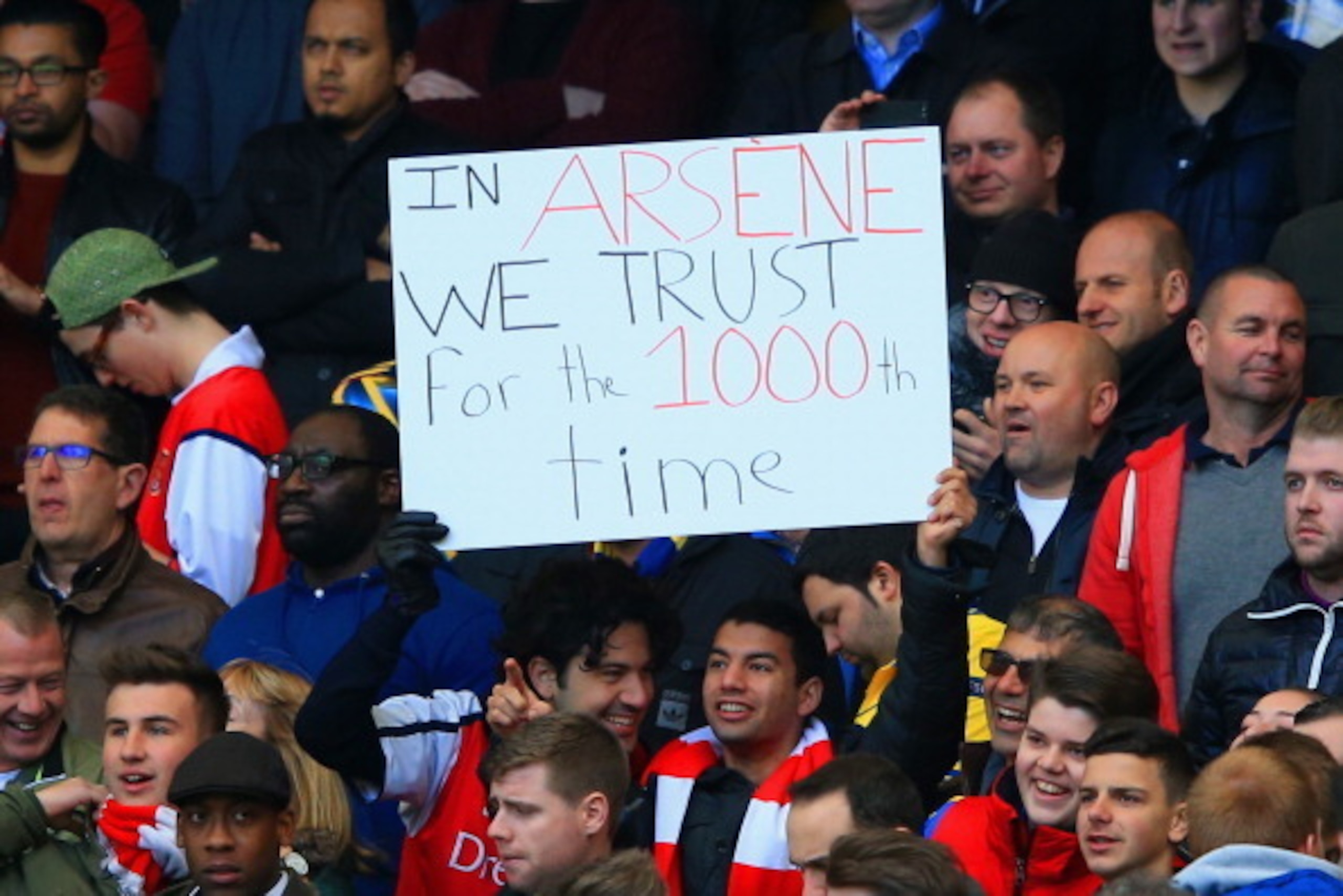 LONDON, ENGLAND - MARCH 22: Arsenal fans hold up a sign to mark Arsene Wenger manager of Arsenal's 1000th game during the Barclays Premier League match between Chelsea and Arsenal at Stamford Bridge on March 22, 2014 in London, England.  (Photo by Richard