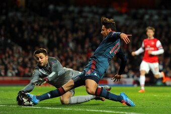 LONDON, ENGLAND - FEBRUARY 19:  Lukasz Fabianski of Arsenal dives to makes a save from Claudio Pizarro of Bayern Muenchen during the UEFA Champions League Round of 16 first leg match between Arsenal and FC Bayern Muenchen at Emirates Stadium on February 1