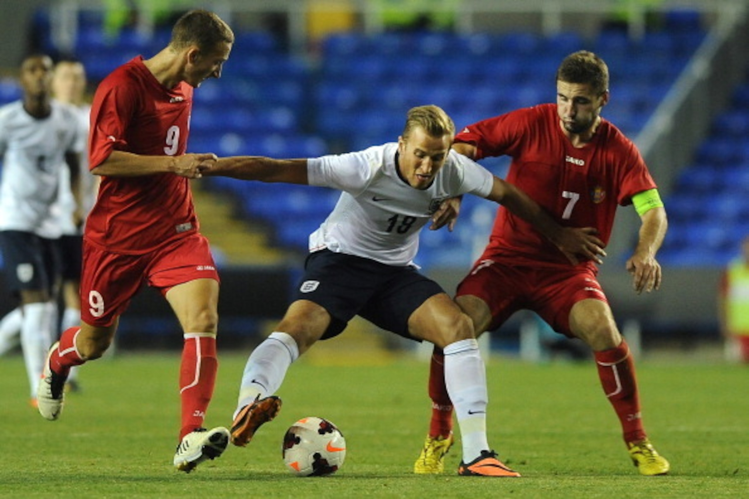 READING, ENGLAND - SEPTEMBER 05: Harry Kane of England looks to hold of Moldova pair Gheorghe Anton (R) and Eugen Zasaviitchi (L) during the 2015 UEFA European U21 Championships Qualifier between England U21 and Moldova U21 at The Madejski Stadium on Sept