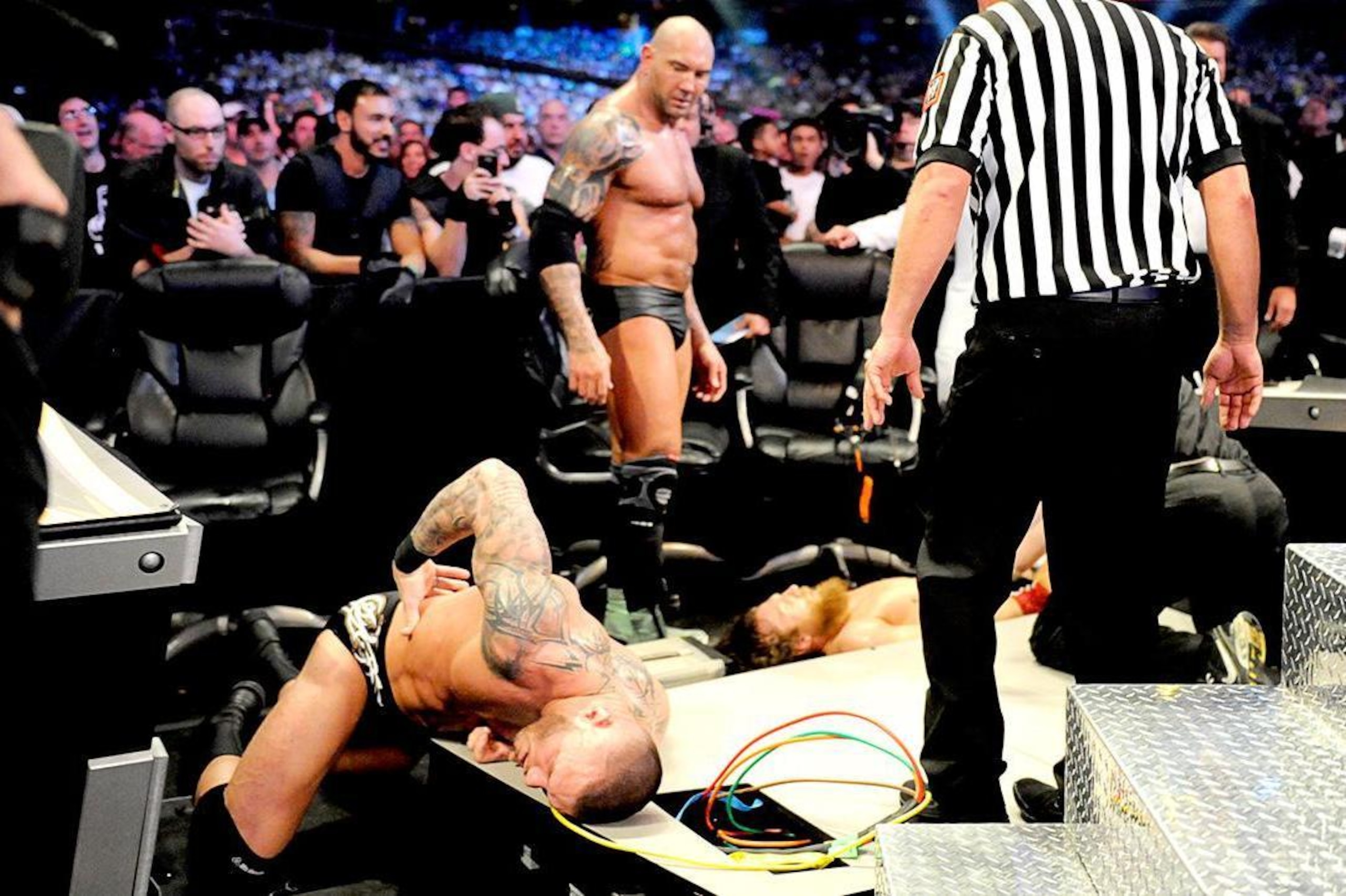 Batista towers over his fallen foes, Randy Orton and Daniel Bryan.