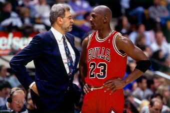 CHICAGO - JUNE 16:  Michael Jordan #23 of the Chicago Bulls discusses strategy with head coach Phil Jackson in Game Six of the 1996 NBA Finals against the Seattle SuperSonics at the United Center on June 16, 1996 in Chicago Iillinois.  The Bulls won 87-75