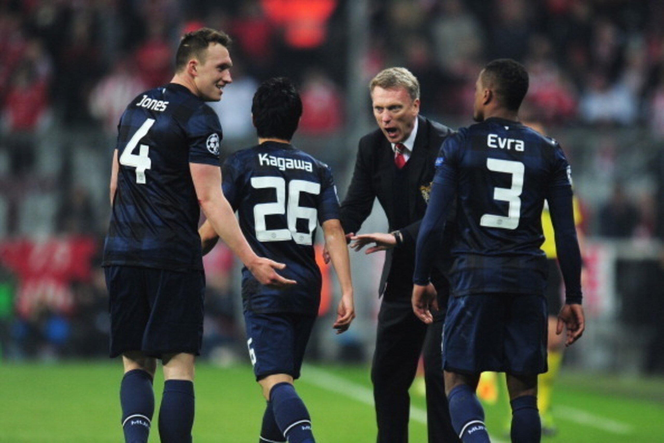 MUNICH, GERMANY - APRIL 09: David Moyes, manager of Manchester United talks to Phil Jones and Shinji Kagawa of Manchester United after the goal scored by Patrice Evra during the UEFA Champions League Quarter Final second leg match between FC Bayern Muench