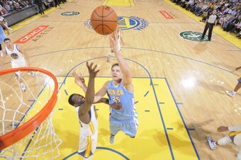 OAKLAND, CA - APRIL 10: Timofey Mozgov #25 of the Denver Nuggets shoots against Draymond Green #23 of the Golden State Warriors on April 10, 2014 at Oracle Arena in Oakland, California. NOTE TO USER: User expressly acknowledges and agrees that, by downloa