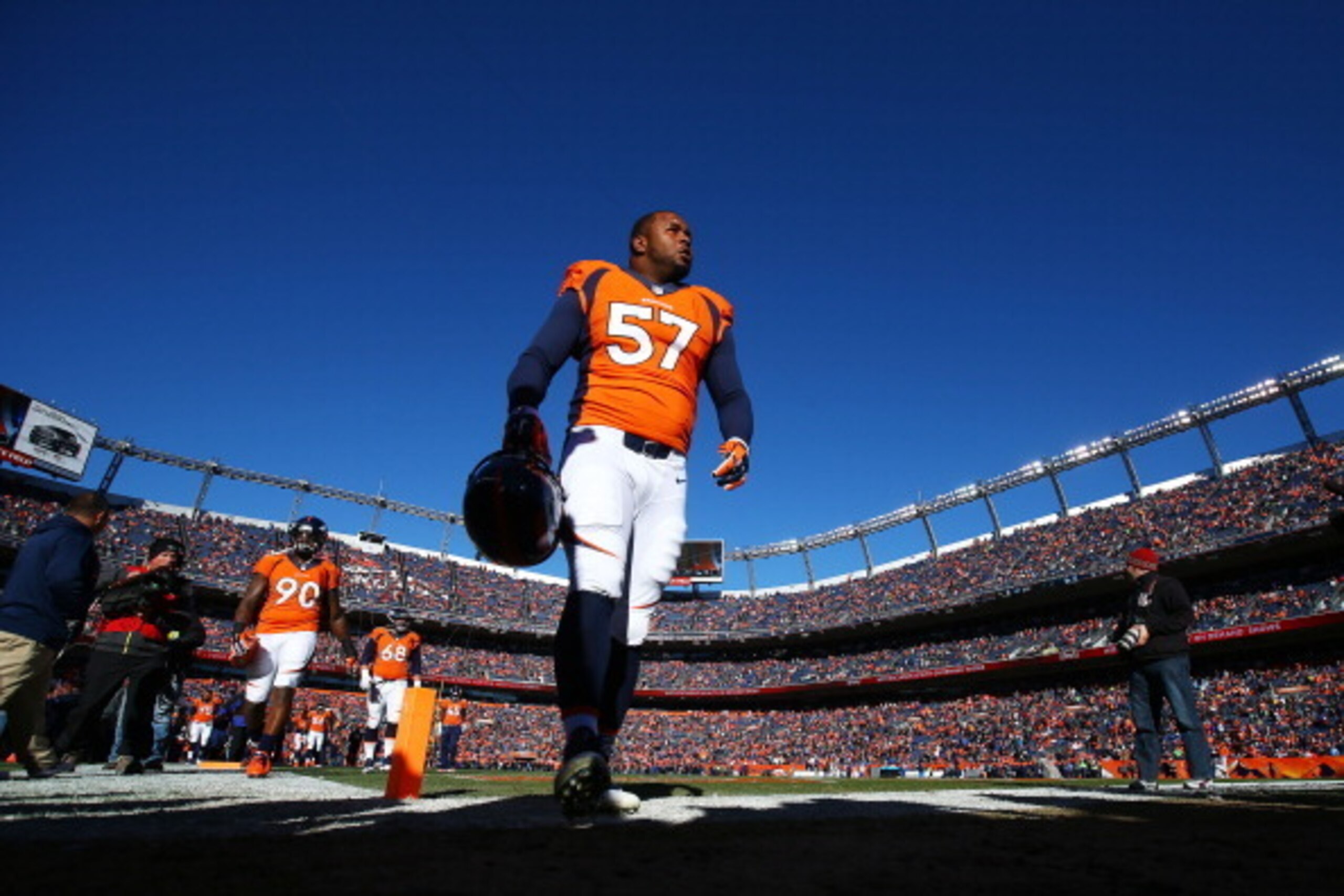 DENVER, CO - JANUARY 12:   Jeremy Mincey #57 of the Denver Broncos walks off the field after warming up prior to their AFC Divisional Playoff Game against the San Diego Chargers at Sports Authority Field at Mile High on January 12, 2014 in Denver, Colorad