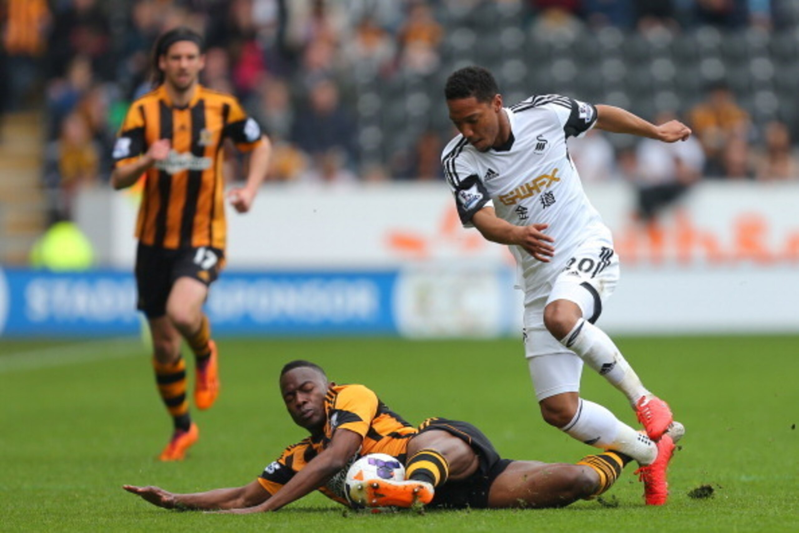 HULL, ENGLAND - APRIL 05:  Hull City's Maynor Figueroa  (grounded) and Swansea City's Jonathan de Guzman compete or the ball during the Barclays Premier League match between Hull City and Swansea City at KC Stadium on April 5, 2014 in Hull, England. (Phot