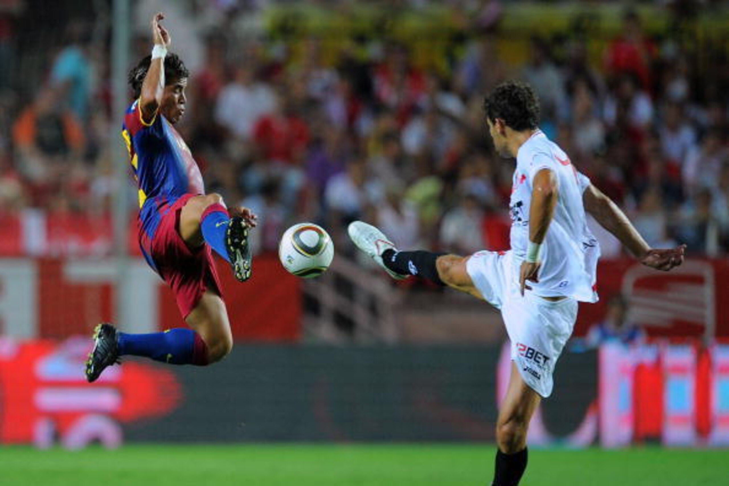 SEVILLE, SPAIN - AUGUST 14:  Jonathan (L) of Barcelona is challenged by Federico Fazio of Sevilla during the Supercopa first leg match between Sevilla and Barcelona at the Sanchez Pizjuan stadium  on August 14, 2010 in Seville, Spain.  (Photo by Denis Doy