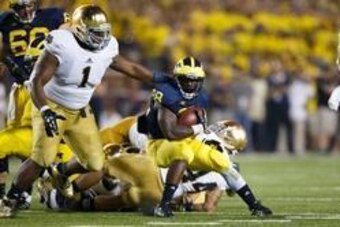 Sep 7, 2013; Ann Arbor, MI, USA; Michigan Wolverines running back Fitzgerald Toussaint (28) runs the ball at Notre Dame Fighting Irish player Louis Nix III (1) in the third quarter at Michigan Stadium. Mandatory Credit: Rick Osentoski-USA TODAY Sports