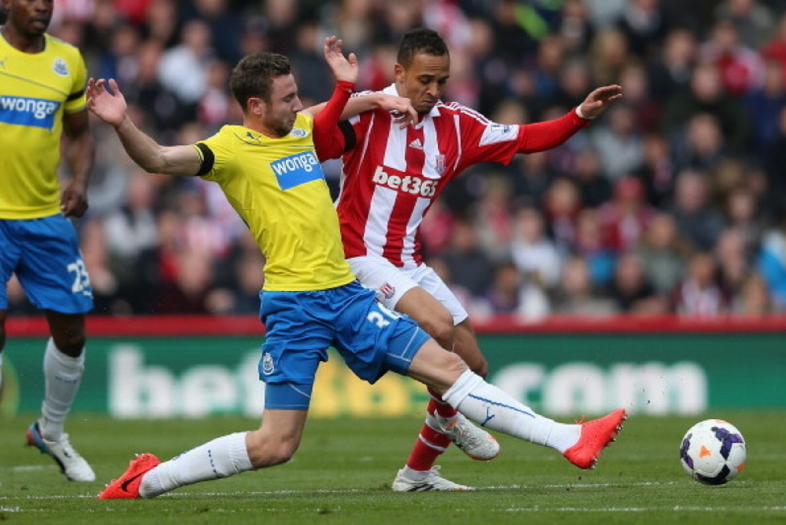 STOKE ON TRENT, ENGLAND - APRIL 12:  Paul Dummett of Newcastle United challenges Peter Odemwingie of Stoke City during the Barclays Premier League match between Stoke City and Newcastle United at Britannia Stadium on April 12, 2014 in Stoke on Trent, Engl