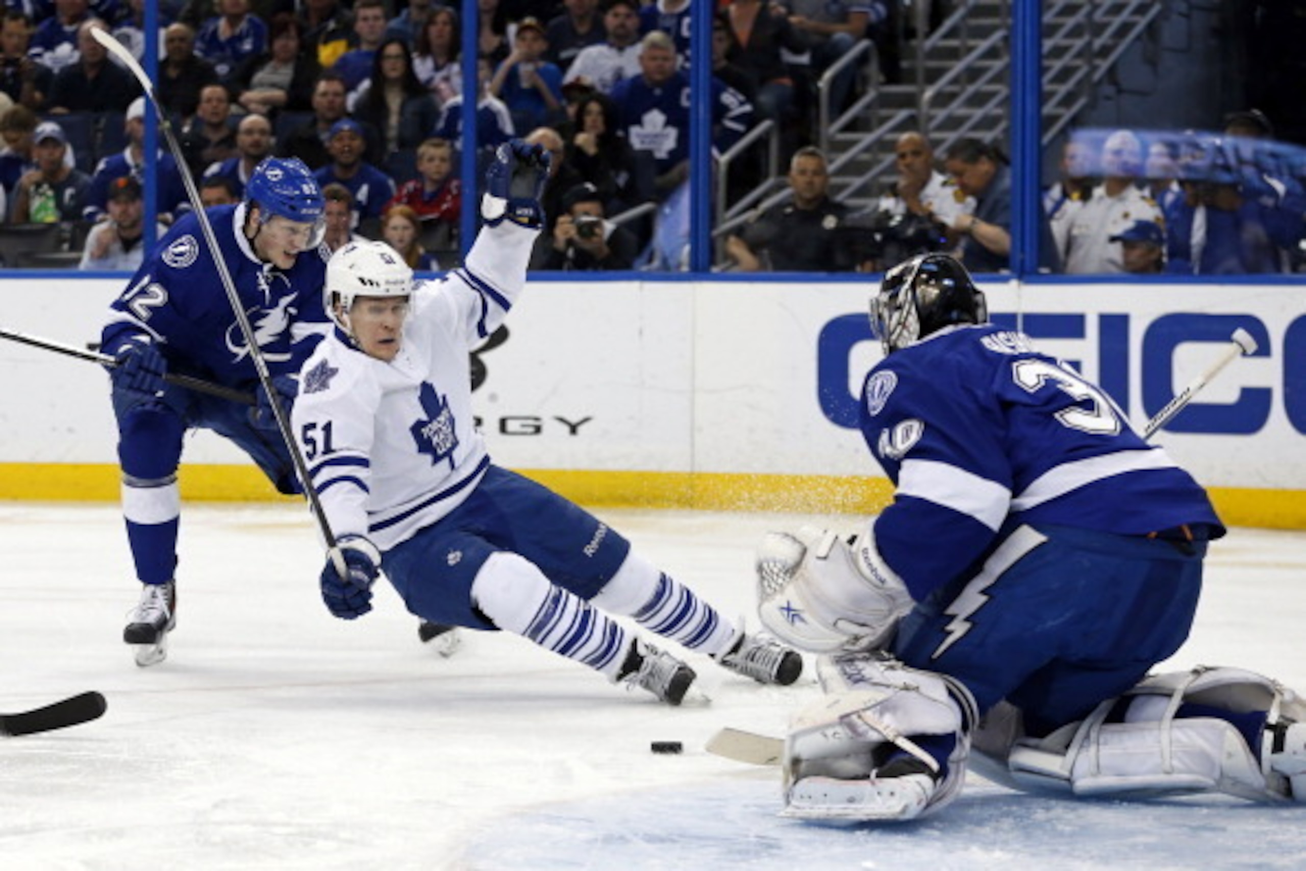 TAMPA, FL - APRIL 8:  Andrej Sustr #62 of the Tampa Bay Lightning checks Jake Gardiner #51 of the Toronto Maple Leafs in front of goalie Ben Bishop #30 at the Tampa Bay Times Forum on April 8, 2014 in Tampa, Florida. (Photo by Mike Carlson/Getty Images)