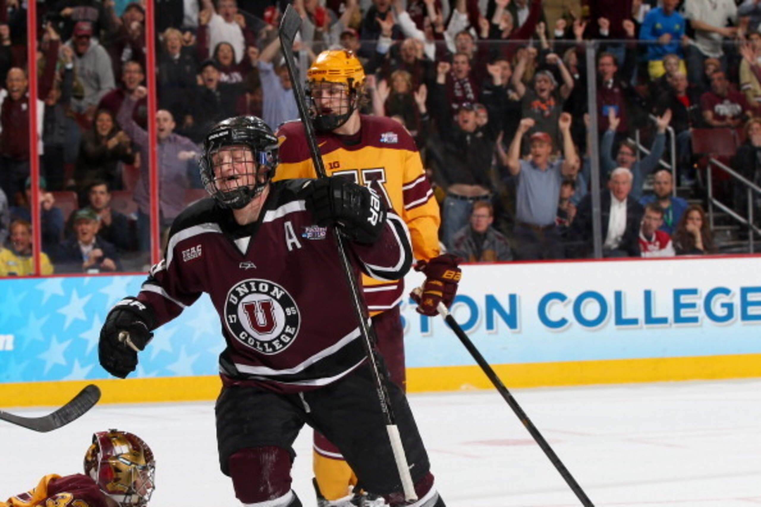 PHILADELPHIA, PA - APRIL 12:  Daniel Carr #9 of the Union College Dutchmen celebrates a teammate's goal as Adam Wilcox #32 of the Minnesota Golden Gophers looks on during the 2014 NCAA Division I Men's Hockey Championship Game at Wells Fargo Center on Apr