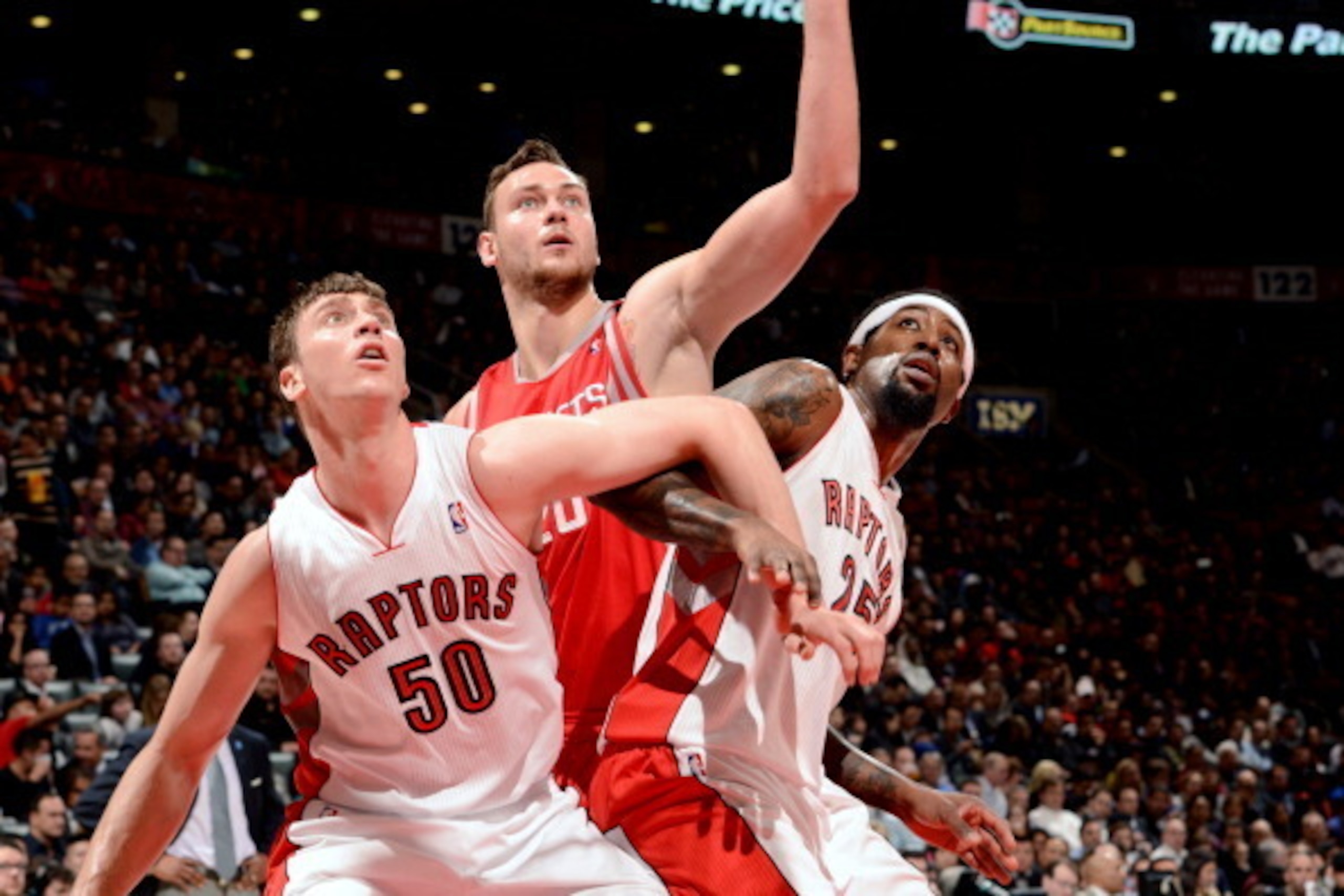 TORONTO, CANADA - April 2: Donatas Motiejunas #20 of the Houston Rockets battles for position against Tyler Hansbrough #50 and John Salmons #25 of the Toronto Raptors on April 2, 2014 at the Air Canada Centre in Toronto, Ontario, Canada.  NOTE TO USER: Us