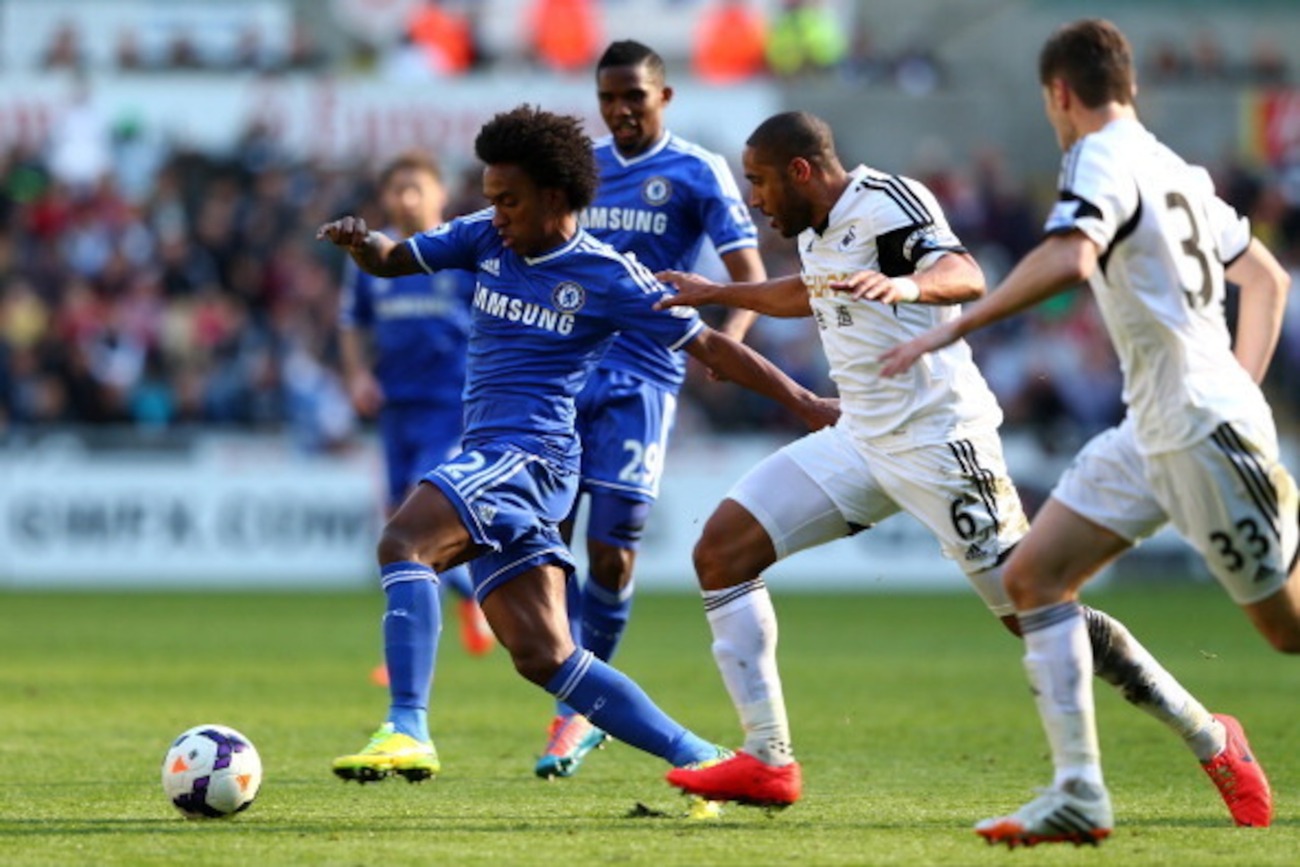SWANSEA, WALES - APRIL 13:  Willian of Chelsea is closed down by Ashley Williams of Swansea during the Barclays Premier League match between Swansea City and Chelsea at Liberty Stadium on April 13, 2014 in Swansea, Wales.  (Photo by Michael Steele/Getty I