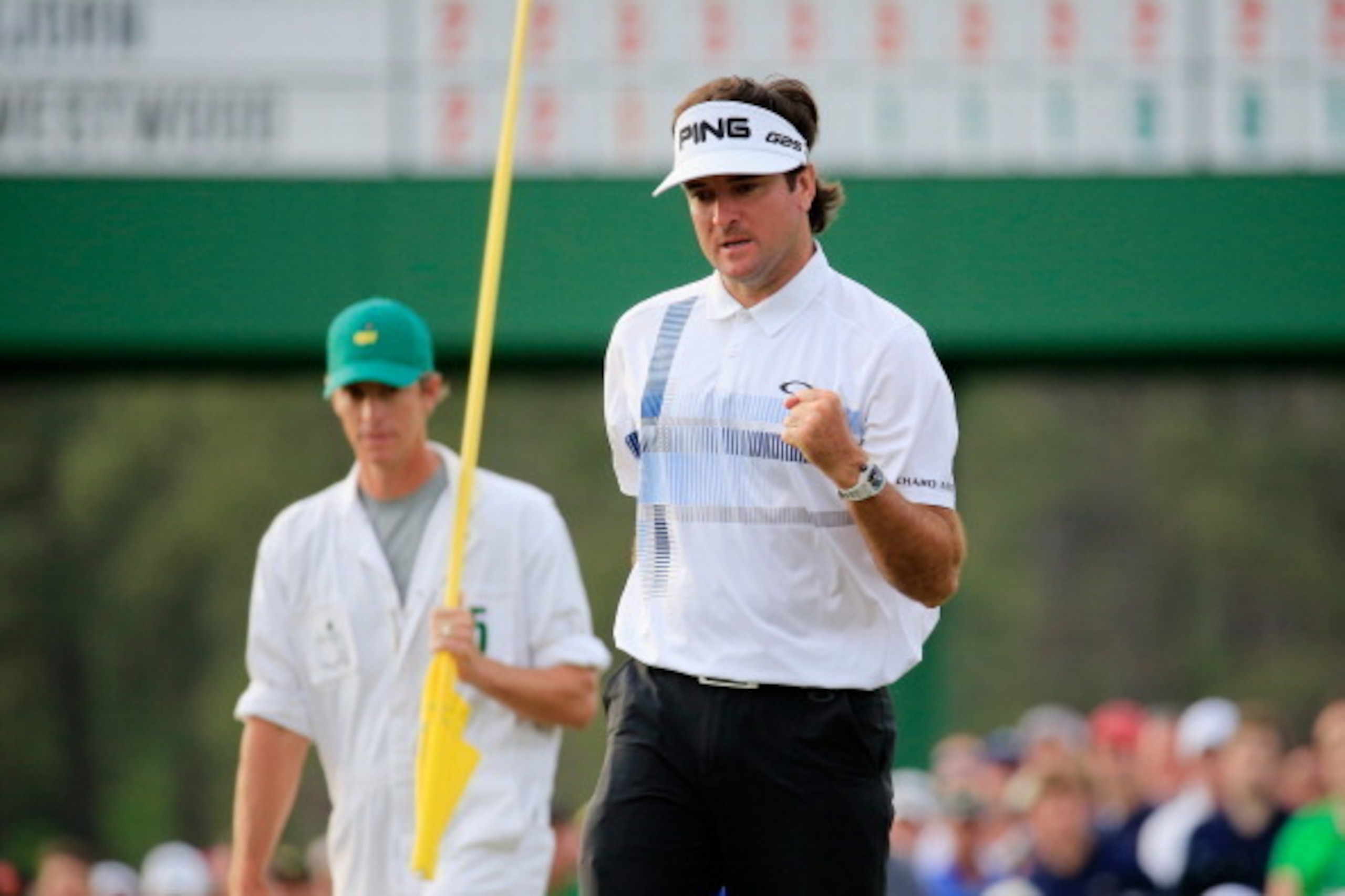 AUGUSTA, GA - APRIL 13:  Bubba Watson of the United States celebrates on the 17th green as his caddie Ted Scott looks on after winning the 2014 Masters Tournament by a three-stroke margin at Augusta National Golf Club on April 13, 2014 in Augusta, Georgia