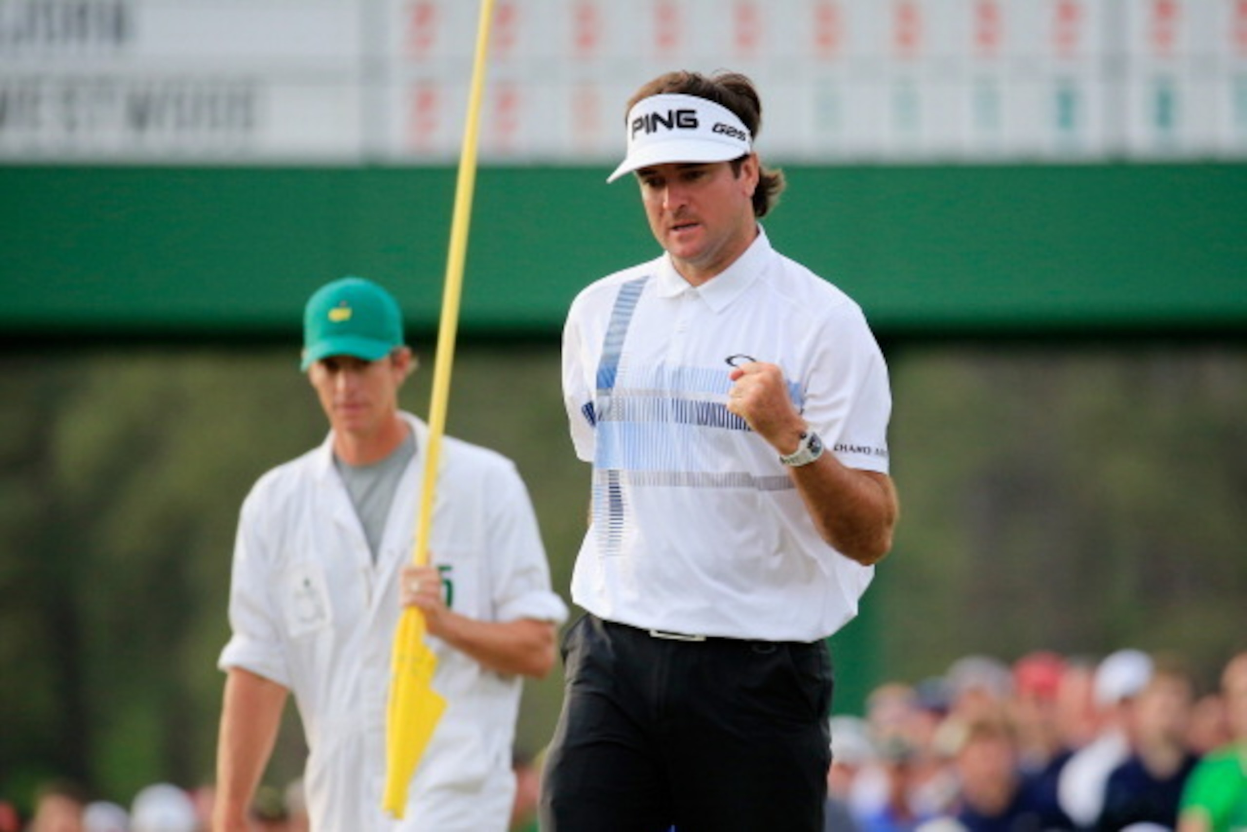 AUGUSTA, GA - APRIL 13:  Bubba Watson of the United States celebrates on the 17th green as his caddie Ted Scott looks on after winning the 2014 Masters Tournament by a three-stroke margin at Augusta National Golf Club on April 13, 2014 in Augusta, Georgia