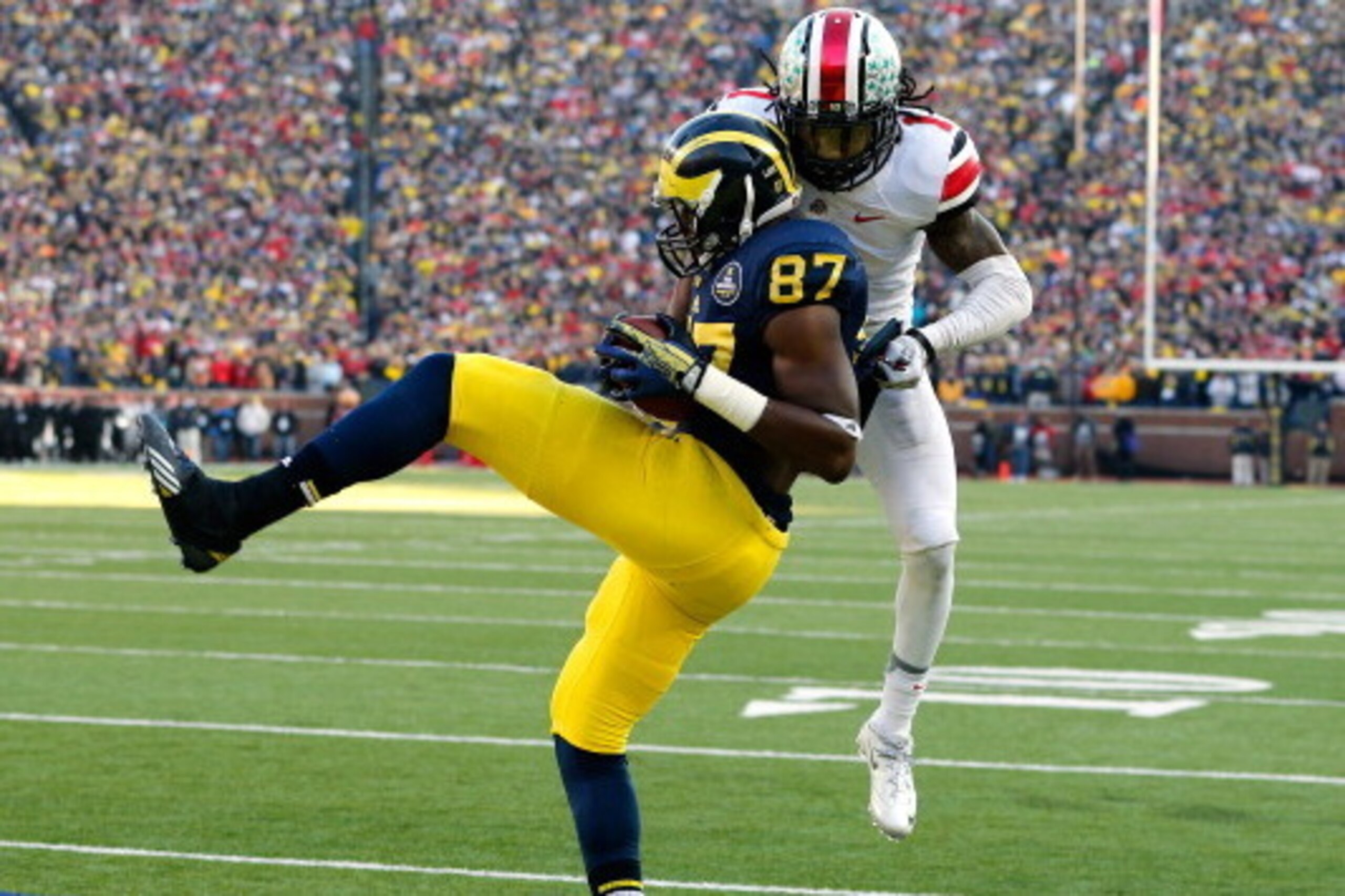 ANN ARBOR, MI - NOVEMBER 30:  Tight end Devin Funchess #87 of the Michigan Wolverines catches a fourth quarter touchdown as cornerback Bradley Roby #1 of the Ohio State Buckeyes defends during a game at Michigan Stadium on November 30, 2013 in Ann Arbor, 