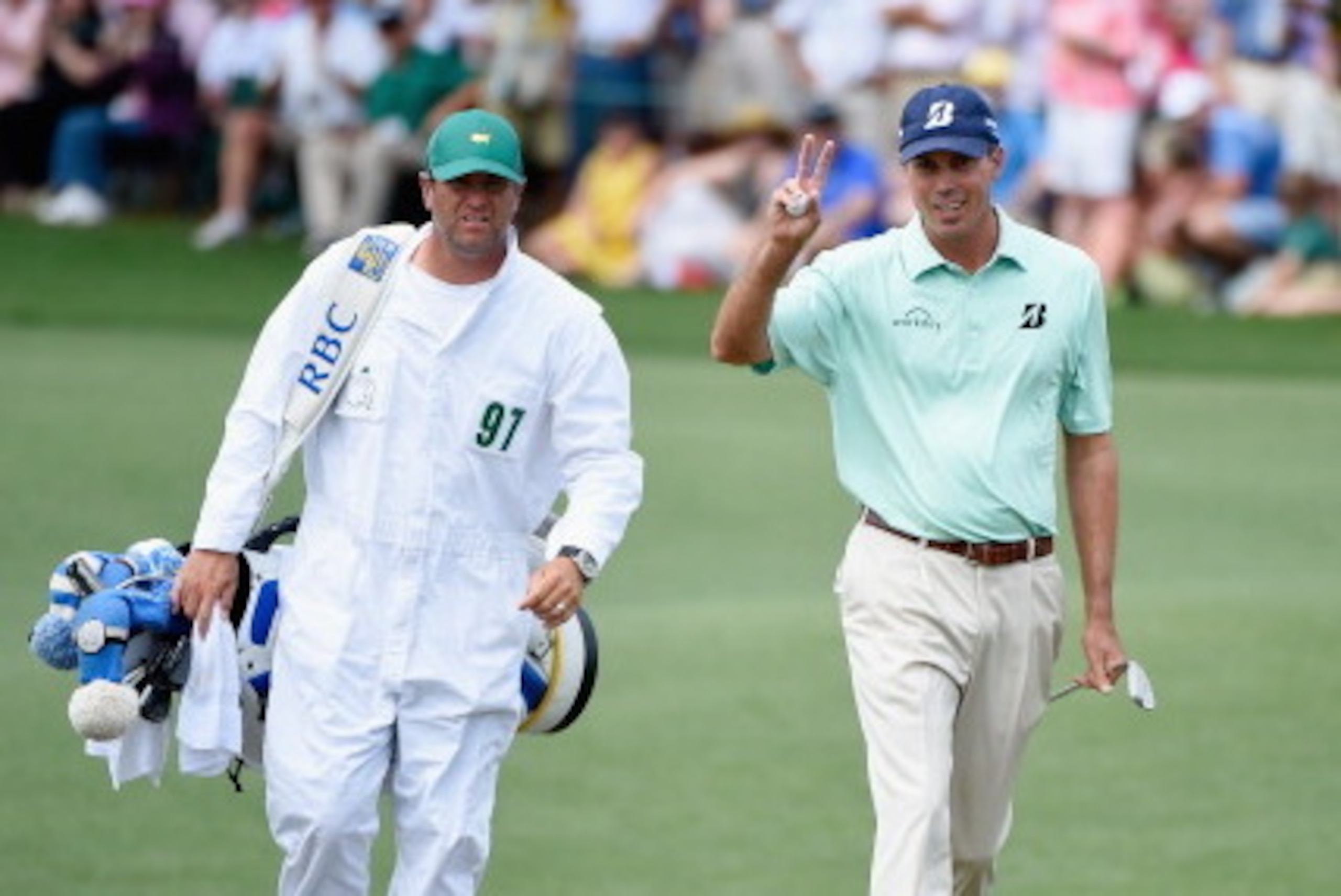 AUGUSTA, GA - APRIL 13:  Matt Kuchar of the United States waves to the gallery as he walks onto the second green with his caddie Lance Bennett during the final round of the 2014 Masters Tournament at Augusta National Golf Club on April 13, 2014 in Augusta