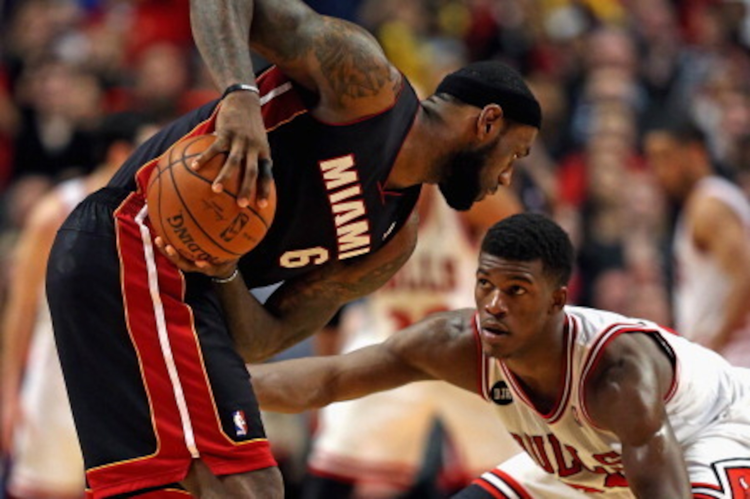 CHICAGO, IL - MARCH 09: LeBron James #6 of the Miami Heat looks to move against Jimmy Butler #21 of the Chicago Bulls at the United Center on March 9, 2014 in Chicago, Illinois. The Bulls defeated the Heat 95-88 in overtime. NOTE TO USER: User expressly a