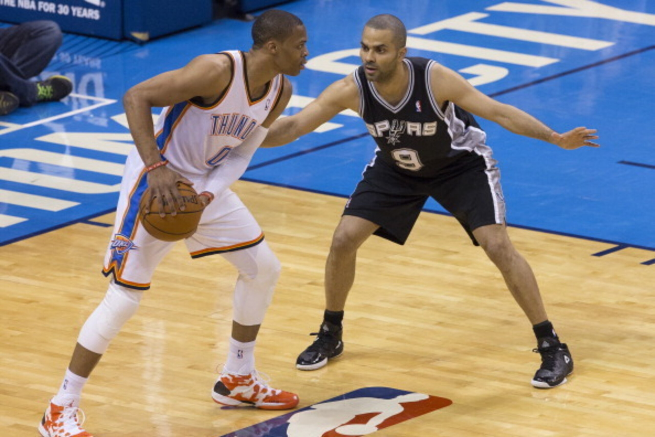 OKLAHOMA CITY, OK - April 3, 2014: Russell Westbrook #0 of the Oklahoma City Thunder handles the ball against Tony Parker #9 of the San Antonio Spurs at the Chesapeake Arena on April 3, 2014 in Oklahoma City, Oklahoma. NOTE TO USER:  User expressly acknow
