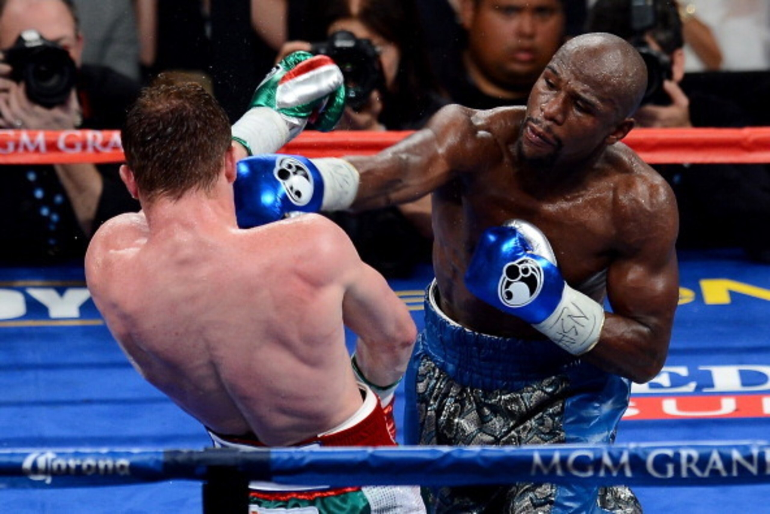 LAS VEGAS, NV - SEPTEMBER 14:  (R-L) Floyd Mayweather Jr. throws a right at Canelo Alvarez during their WBC/WBA 154-pound title fight at the MGM Grand Garden Arena on September 14, 2013 in Las Vegas, Nevada.  (Photo by Ethan Miller/Getty Images)