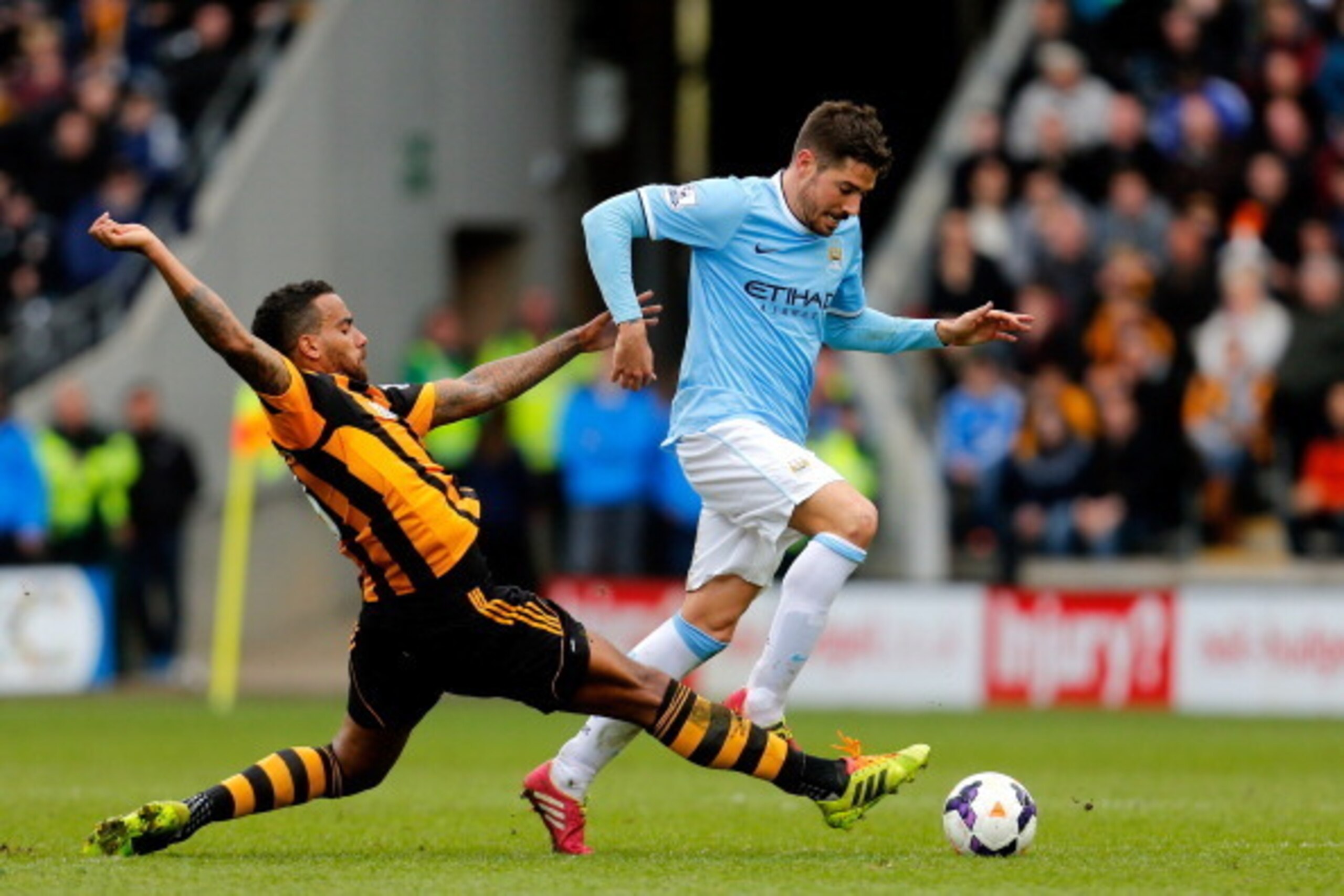 HULL, ENGLAND - MARCH 15:  Javi Garcia of Manchester City is tackled by Tom Huddlestone of Hull City during the Barclays Premier league match between Hull City and Manchester City at KC Stadium on March 15, 2014 in Hull, England.  (Photo by Paul Thomas/Ge