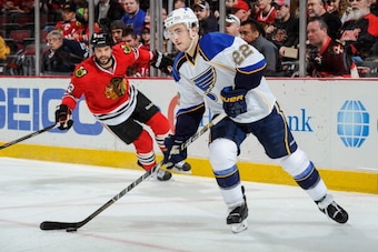CHICAGO, IL - APRIL 6: Kevin Shattenkirk #22 of the St. Louis Blues grabs the puck as Brandon Bollig #52 of the Chicago Blackhawks skates in the background during the NHL game on April 06, 2014 at the United Center in Chicago, Illinois. (Photo by Bill Smi CHICAGO, IL - APRIL 6: Kevin Shattenkirk #22 of the St. Louis Blues grabs the puck as Brandon Bollig #52 of the Chicago Blackhawks skates in the background during the NHL game on April 06, 2014 at the United Center in Chicago, Illinois. (Photo by Bill Smi