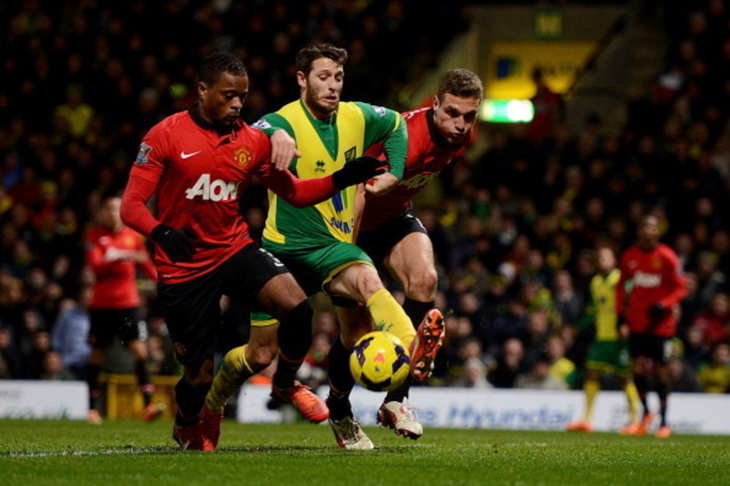 NORWICH, ENGLAND - DECEMBER 28:  Patrice Evra and Nemanja Vidic Manchester United battle with Wes Hoolahan of Norwich City during the Barclays Premier League match between Norwich City and  Manchester United at Carrow Road on December 28, 2013 in Norwich,
