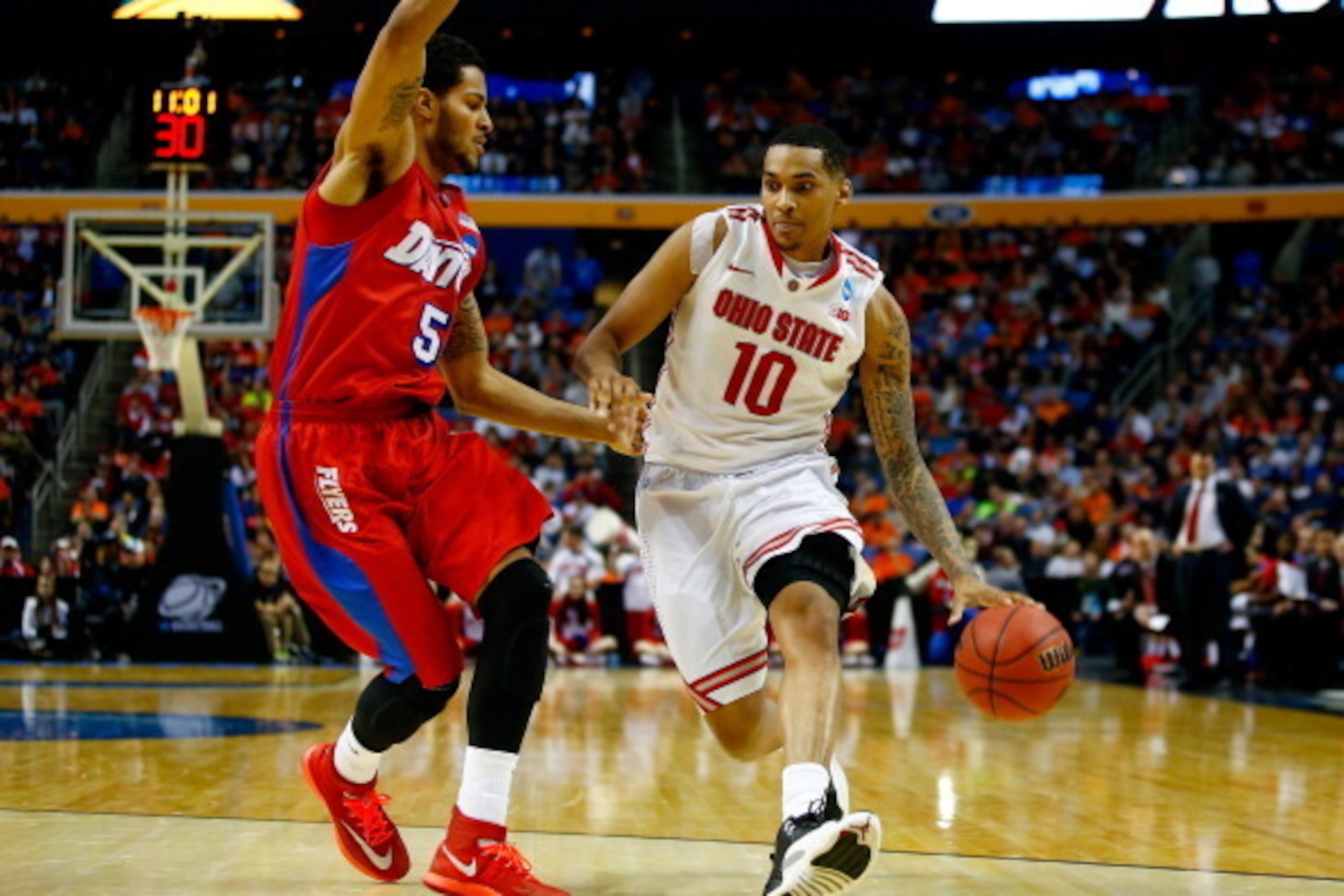 BUFFALO, NY - MARCH 20: LaQuinton Ross #10 of the Ohio State Buckeyes drives to the basket as Devin Oliver #5 of the Dayton Flyers defends during the second round of the 2014 NCAA Men's Basketball Tournament at the First Niagara Center on March 20, 2014 i BUFFALO, NY - MARCH 20: LaQuinton Ross #10 of the Ohio State Buckeyes drives to the basket as Devin Oliver #5 of the Dayton Flyers defends during the second round of the 2014 NCAA Men's Basketball Tournament at the First Niagara Center on March 20, 2014 i