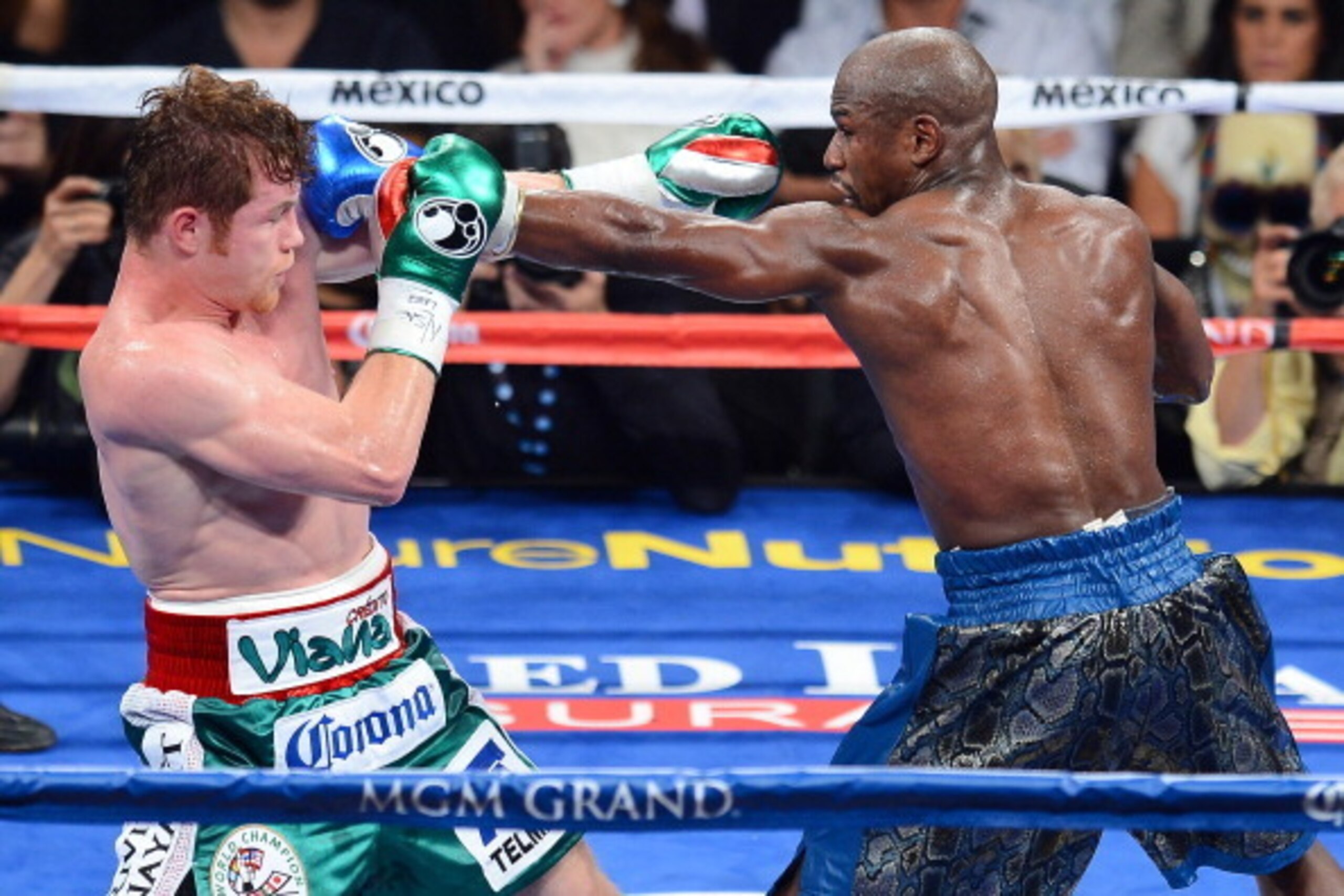 LAS VEGAS, NV - SEPTEMBER 14:  (R-L) Floyd Mayweather Jr. throws a left at Canelo Alvarez during their WBC/WBA 154-pound title fight at the MGM Grand Garden Arena on September 14, 2013 in Las Vegas, Nevada.  (Photo by Ethan Miller/Getty Images)