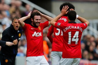 NEWCASTLE UPON TYNE, ENGLAND - APRIL 05: Juan Mata of Manchester United (L) celebrates with team mate Javier Hernandez after scoring their first goal during the Barclays Premier League match between Newcastle United and Manchester United at St James' Park