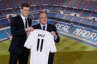 MADRID, SPAIN - SEPTEMBER 02:  Gareth Bale shows his new Real Madrid shirt as he stands alongside president Florentino Perez during his presentation as a new Real Madrid player at Estadio Santiago Bernabeu on September 2, 2013 in Madrid, Spain.  (Photo by