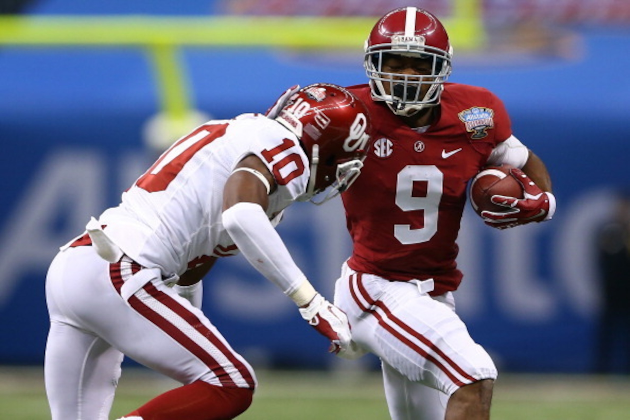 NEW ORLEANS, LA - JANUARY 02:  Amari Cooper #9 of the Alabama Crimson Tide is pushed out of bounds by Quentin Hayes#10 of the Oklahoma Sooners during the Allstate Sugar Bowl at the Mercedes-Benz Superdome on January 2, 2014 in New Orleans, Louisiana.  (Ph