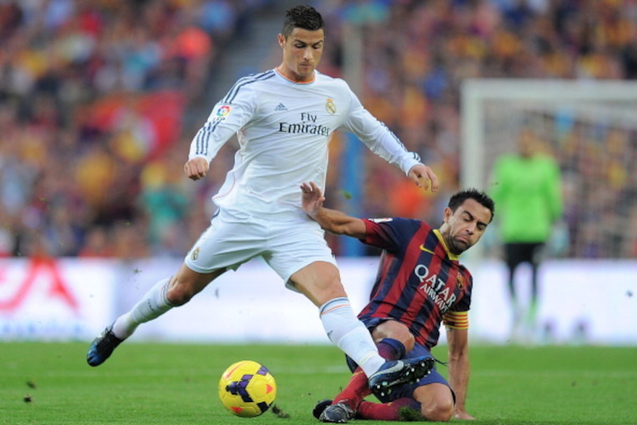 BARCELONA, SPAIN - OCTOBER 26:  Cristiano Ronaldo of Real Madrid CF (L) is tackled by Xavi Hernandez of FC Barcelona during the La Liga match between FC Barcelona and Real Madrid CF at Camp Nou stadium on October 26, 2013 in Barcelona, Spain.  (Photo by D
