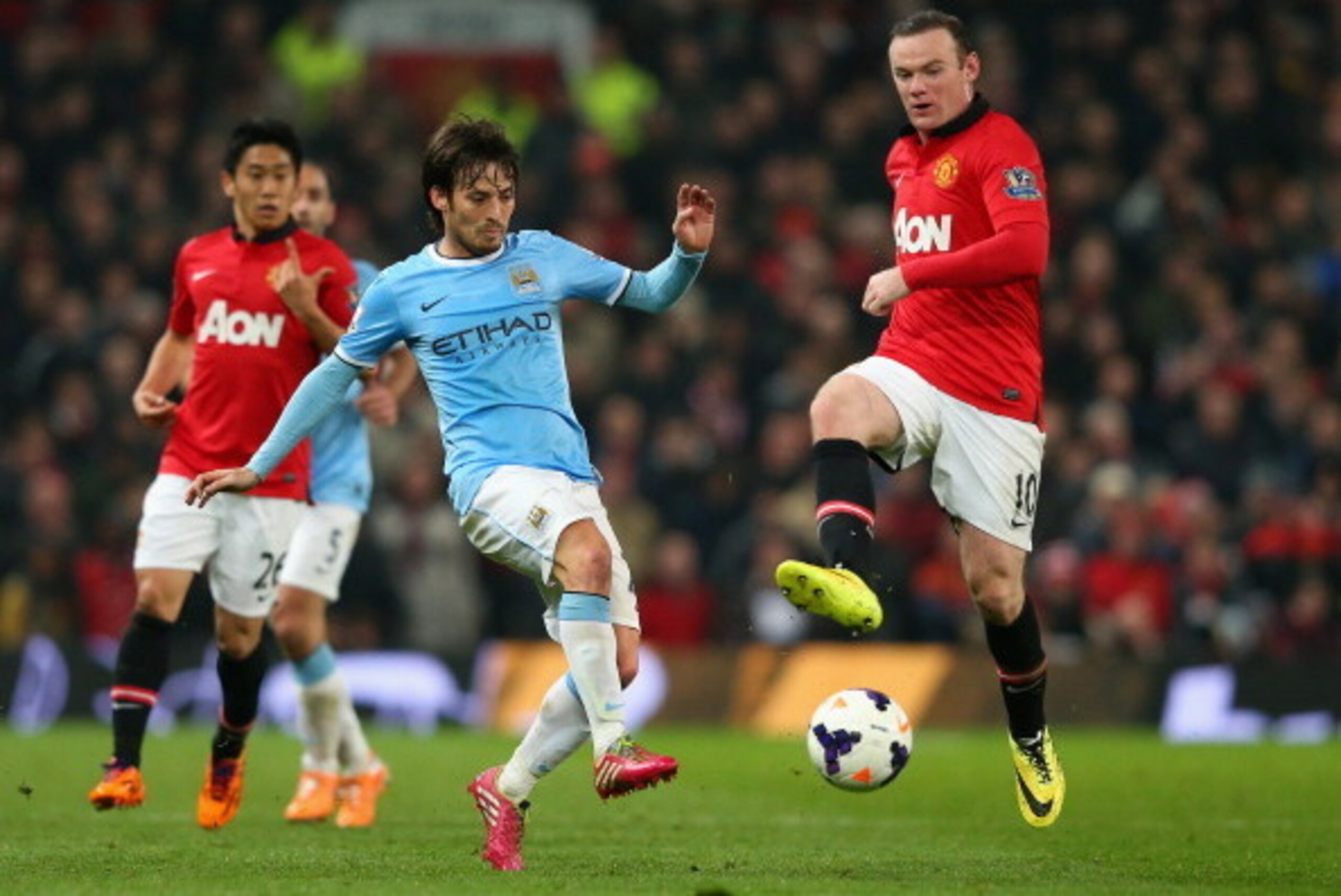 MANCHESTER, ENGLAND - MARCH 25:  David Silva of Manchester City competes with Wayne Rooney of Manchester United during the Barclays Premier League match between Manchester United and Manchester City at Old Trafford on March 25, 2014 in Manchester, England