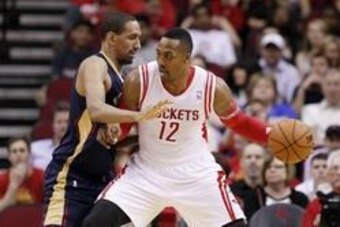 Apr 12, 2014; Houston, TX, USA; Houston Rockets center Dwight Howard (12) drives against New Orleans Pelicans center Alexis Ajinca (left) during the first half at Toyota Center. Mandatory Credit: Soobum Im-USA TODAY Sports