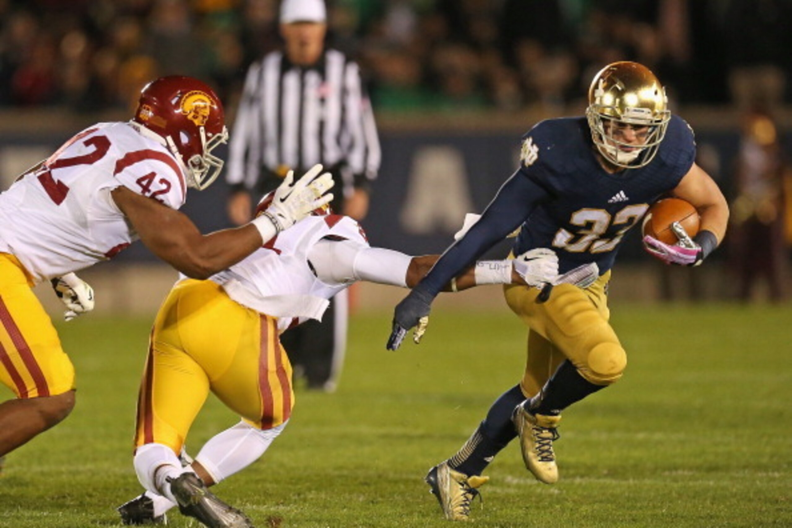 SOUTH BEND, IN - OCTOBER 19:  Cam McDaniel #33 of the Notre Dame Fighting Irish breaks a tackle by Su'a Cravens #21 of the University of Southern California Trojans at Notre Dame Stadium on October 19, 2013 in South Bend, Indiana.  (Photo by Jonathan Dani