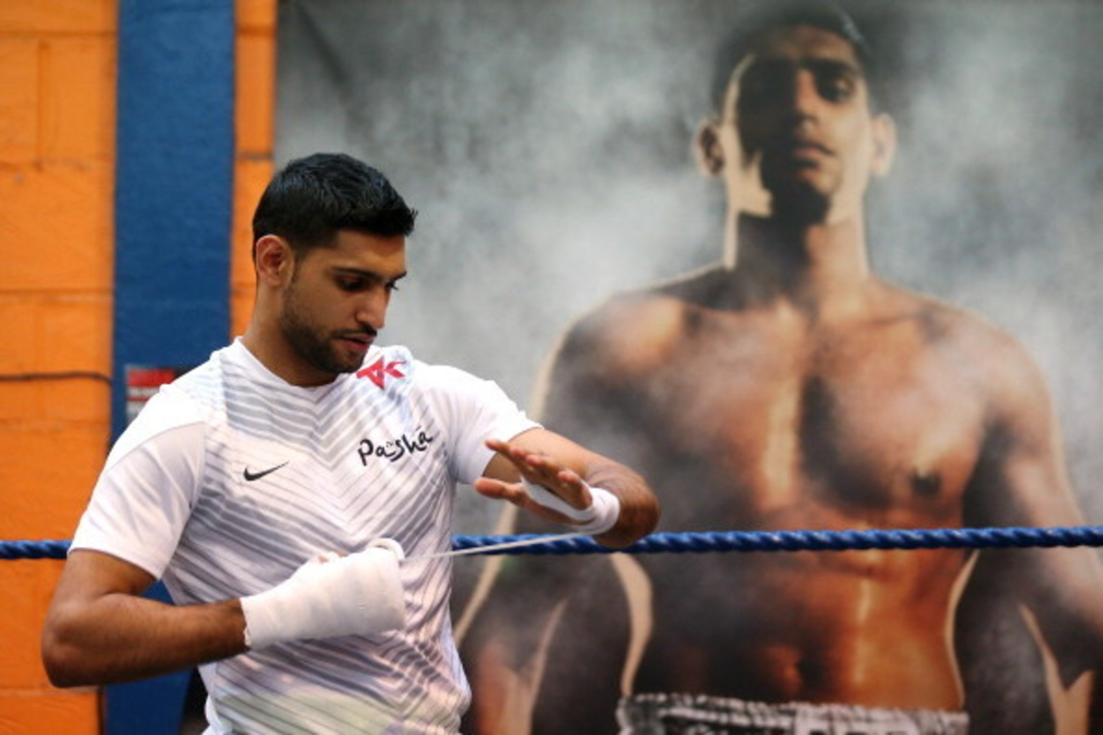 BOLTON, ENGLAND - MARCH 24:  Amir Khan tapes his hands up prior to a media workout at the Gloves Community Centre on March 24, 2014 in Bolton, England.  (Photo by Alex Livesey/Getty Images)