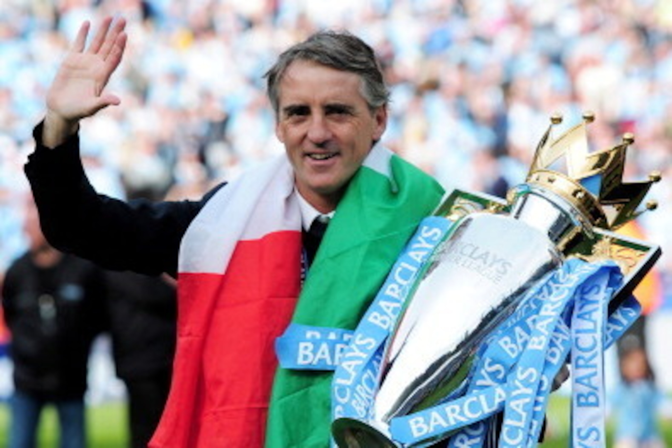 MANCHESTER, ENGLAND - MAY 13:  Roberto Mancini the manager of Manchester City celebrates with the trophy following the Barclays Premier League match between Manchester City and Queens Park Rangers at the Etihad Stadium on May 13, 2012 in Manchester, Engla