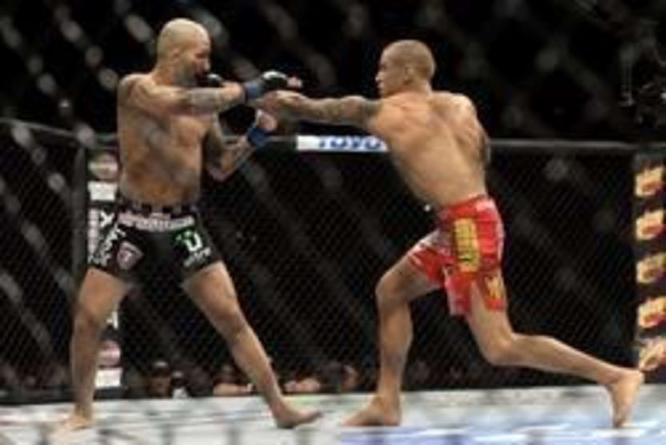 Apr 16, 2014; Quebec City, Quebec, Canada; Dustin Poirier (red  gloves) hits Akira Corassani (blue gloves), during their featherweight bout at Colisee Pepsi. Poirier won by KO/TKO. Mandatory Credit: Eric Bolte-USA TODAY Sports