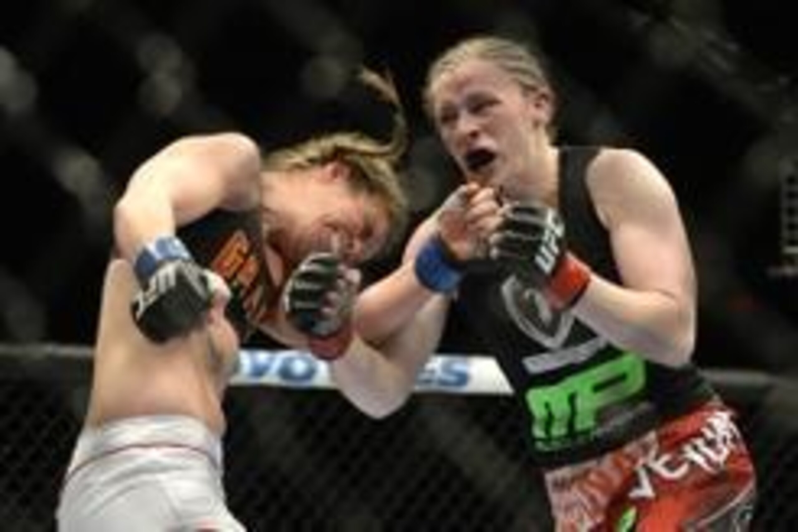 Apr 16, 2014; Quebec City, Quebec, Canada; Sarah Kaufman ( red gloves) Victoria, BC,Canada take a  hit Leslie Smith (blue gloves), Pleasant Hiil, CA during their women's bantamweight bout at Colisee Pepsi. Mandatory Credit: Eric Bolte-USA TODAY Sports