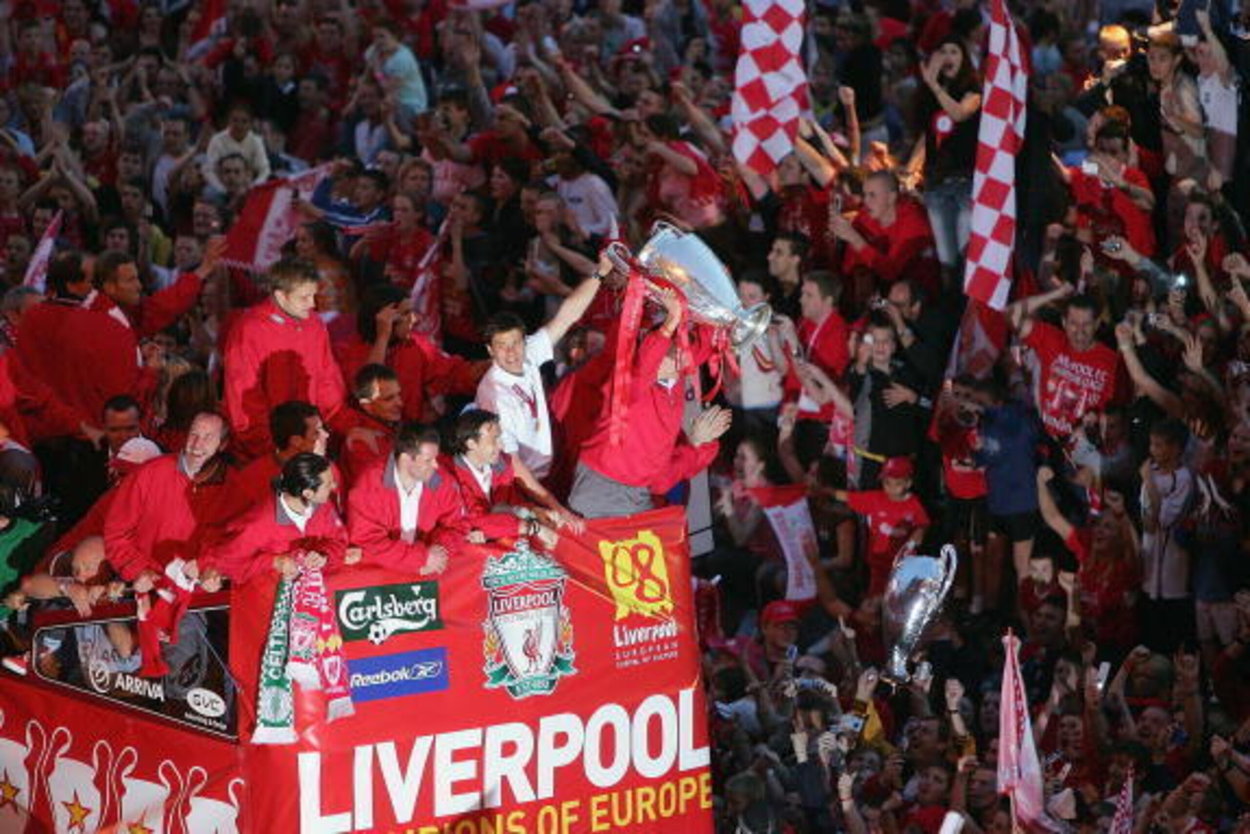 LIVERPOOL, ENGLAND - MAY 26:  Captain Steven Gerrard holds the trophy aloft as the Liverpool team ride on an open top bus through a mass of fans as they arrive at St. George's Hall during the Liverpool Champions League Victory Parade on May 26, 2005 in Li