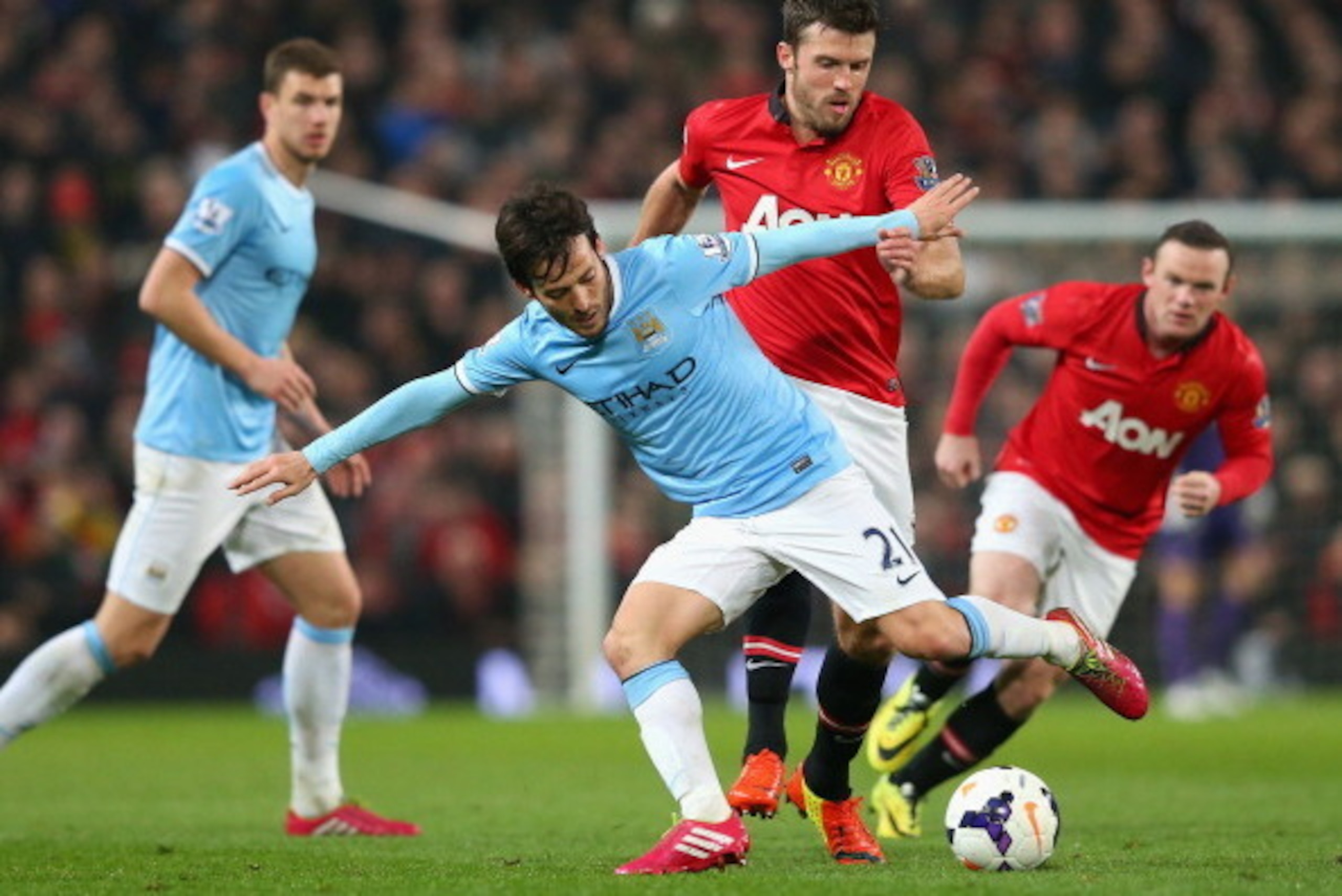 MANCHESTER, ENGLAND - MARCH 25:  David Silva of Manchester City competes with Michael Carrick of Manchester United during the Barclays Premier League match between Manchester United and Manchester City at Old Trafford on March 25, 2014 in Manchester, Engl