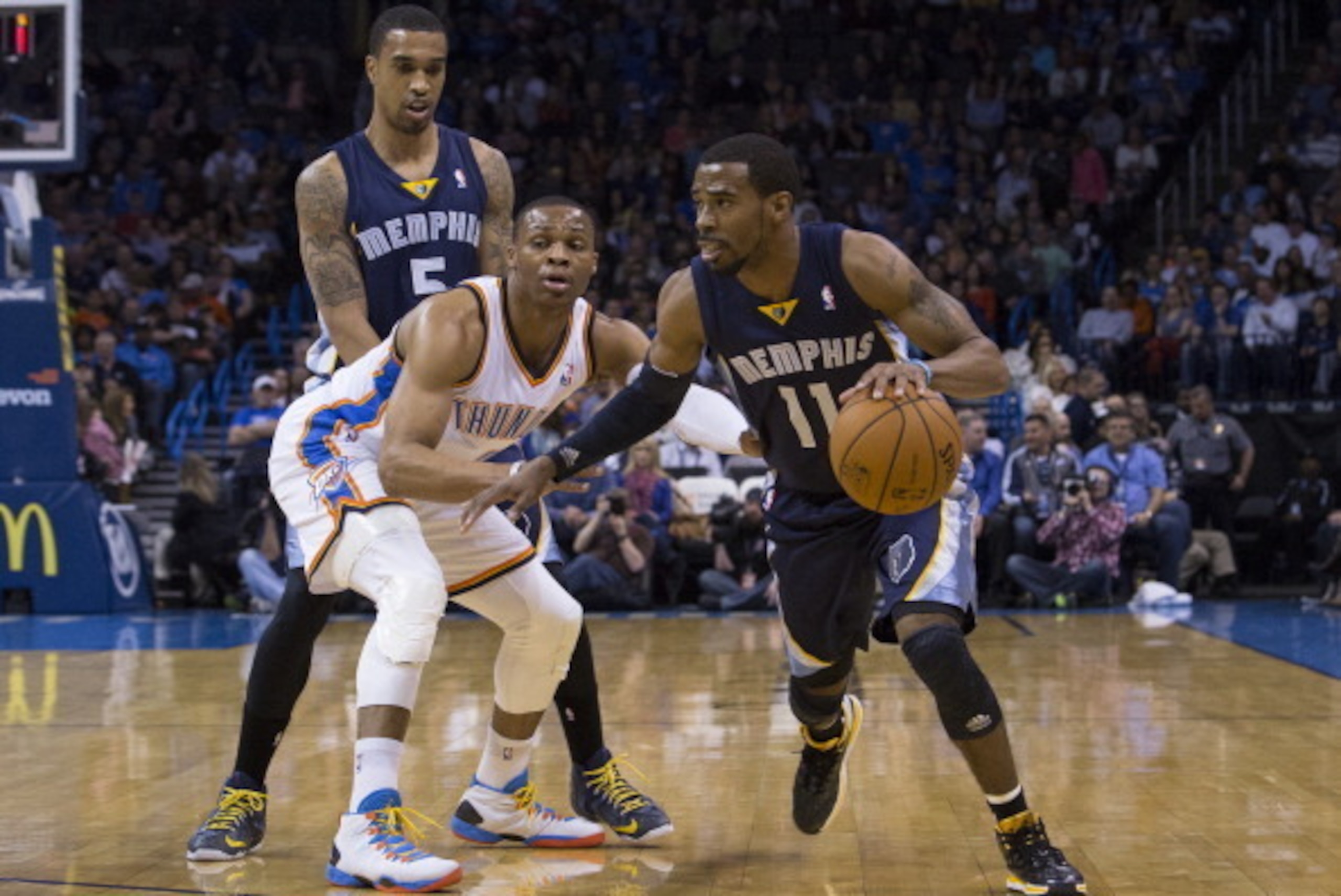 OKLAHOMA CITY, OK - FEBRUARY 28, 2014:  Mike Conley #11 of the Memphis Grizzlies handles the ball against Russell Westbrook #0 of the Oklahoma City Thunder the Chesapeake Arena on February 28, 2014 in Oklahoma City, Oklahoma. NOTE TO USER:  User expressly